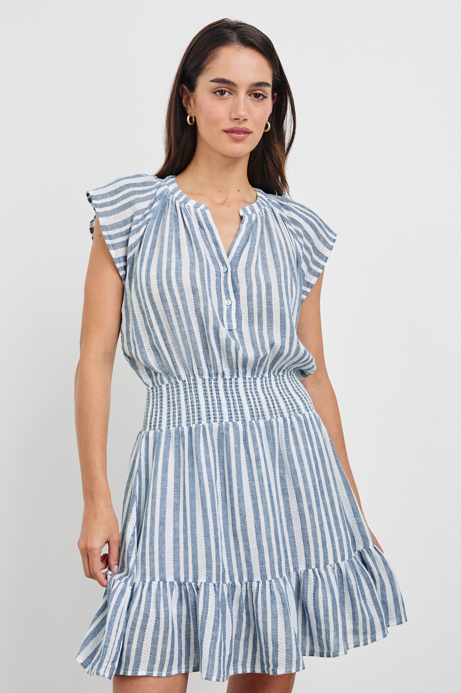 Augustine Mini Dress with Flutter Sleeves, V-Neck Button Front, Elastic Gathered Waist and a Tiered Flounce Hem in Jalisco Stripe Colorway. Front View Shown on Model.