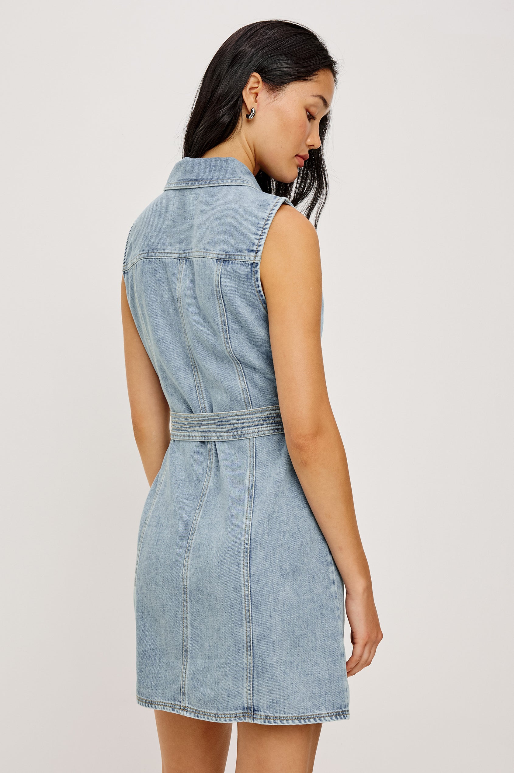 Aurora Sleeveless Mini Dress in Cotton Lyocell Denim With Collar, Front Exposed Zipper, Adjustable Belted Ties, Side Flap Pockets in Faded Indigo Colorway - Upper Body Back View Featured on Model