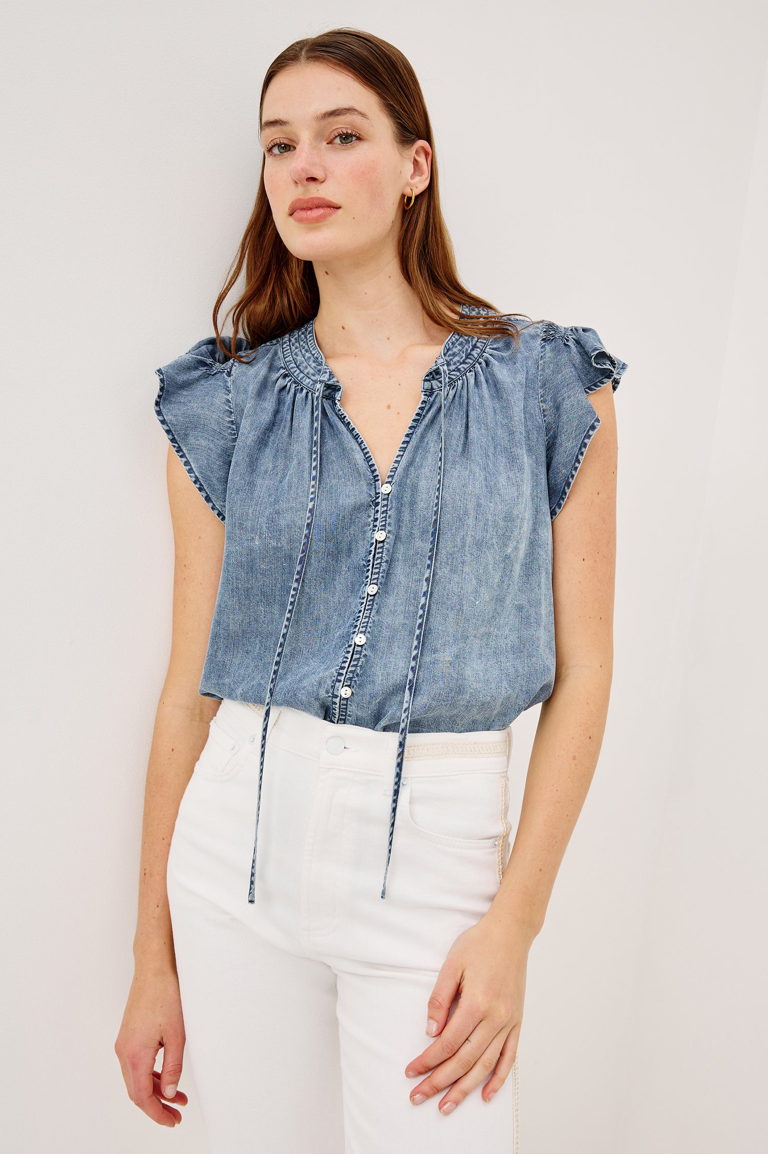 Aviva Top in TENCEL™ Denim With Smocked Flutter Sleeves Split V-Neck With Embroidered Collar and Self-Ties and Front Buttons in Blue Ridge Colorway - Upper Body Front View Featured on Model