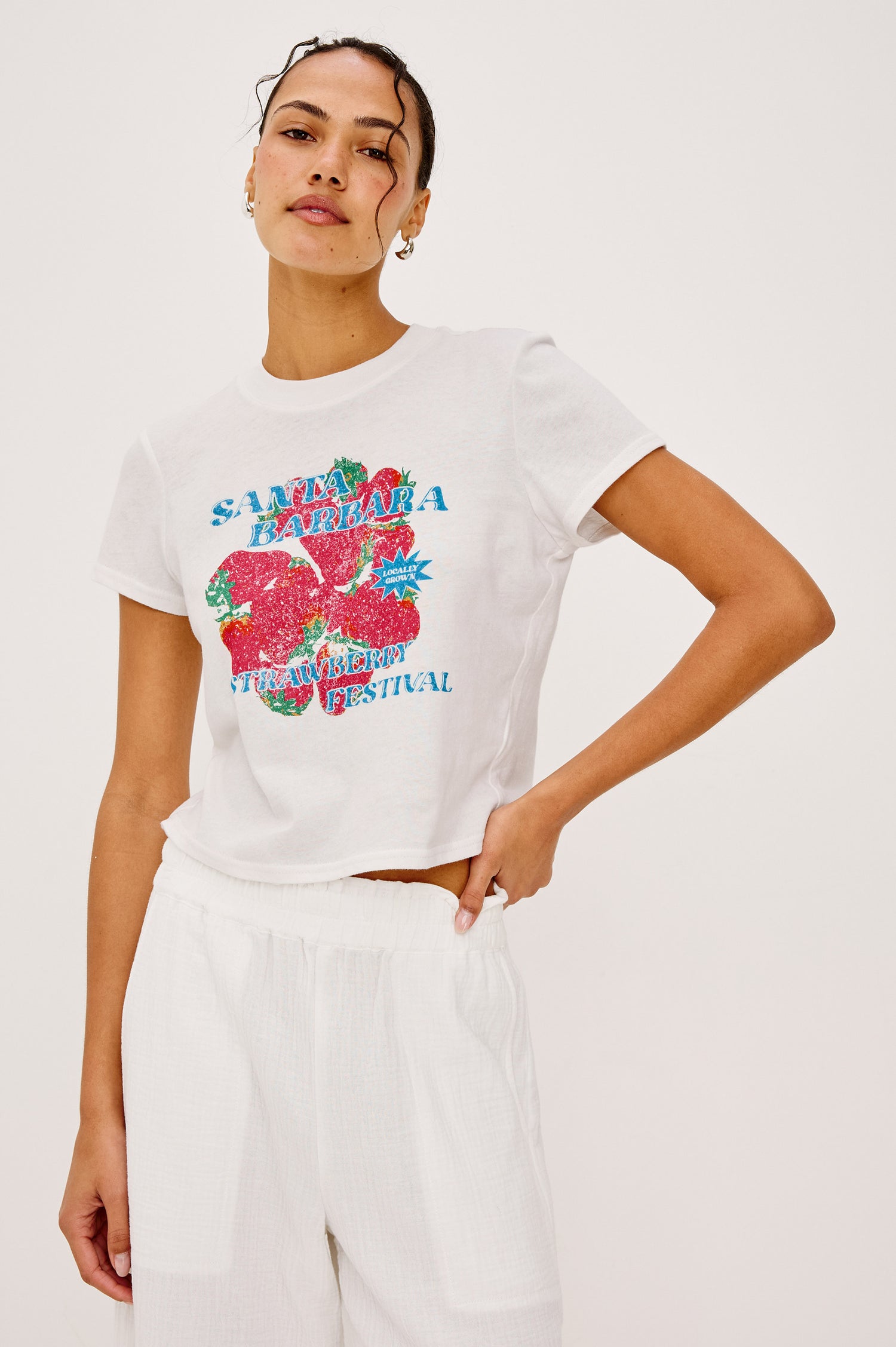 Baby Tee in Cotton With Crew Neckline, Short Sleeves, Boxy, Cropped FIt, and Graphic Print at Front in Santa Barbara Strawberry Festival Colorway - Upper Body Front View Featured on Model