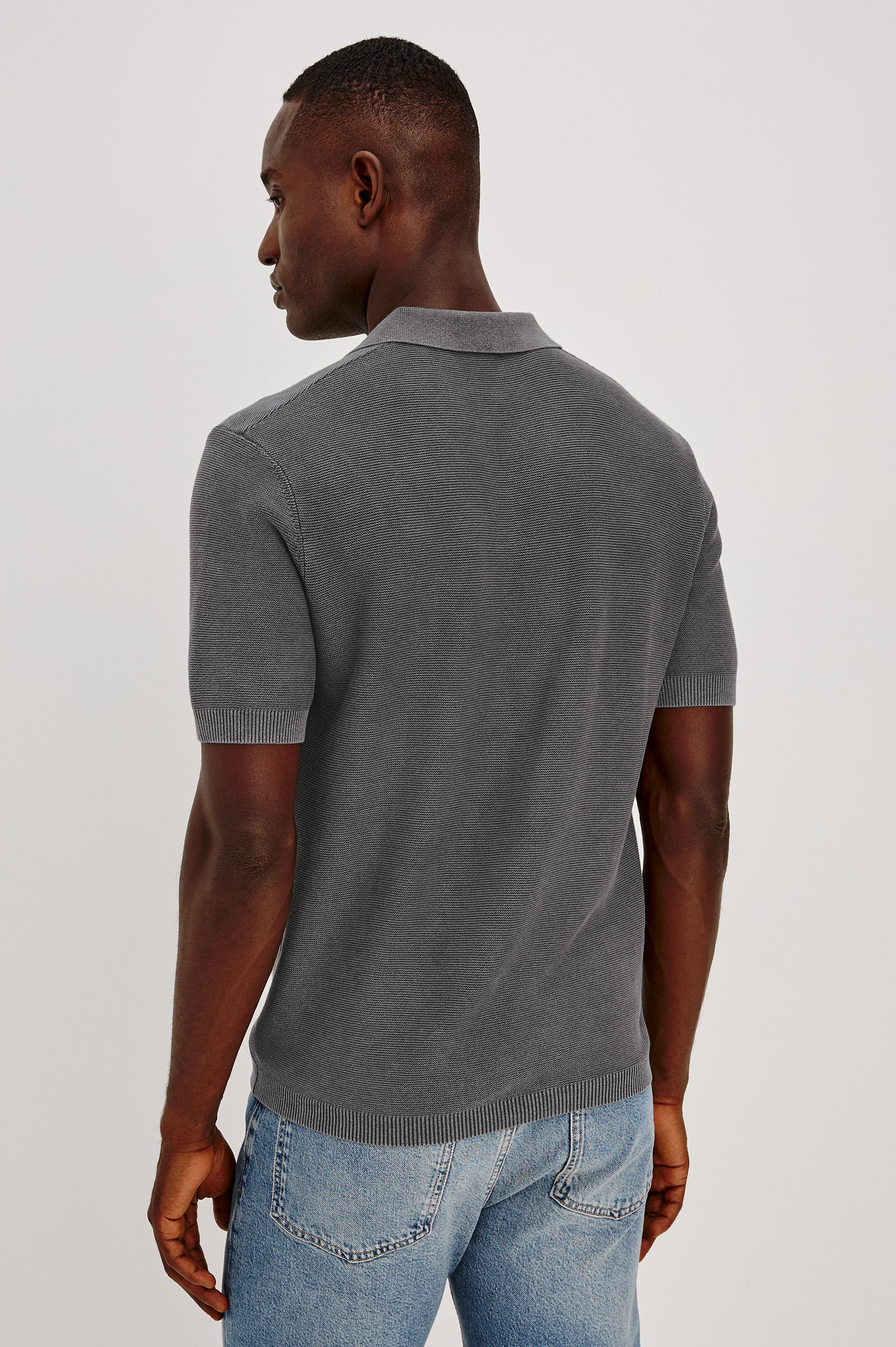 Baker Polo Shirt in Cotton Knit With Sun-Washed Effect, Open-Placket Collar, Short Sleeves, and Relaxed Fit in Sunfaded Black Colorway - Upper Body Back View Featured on Model