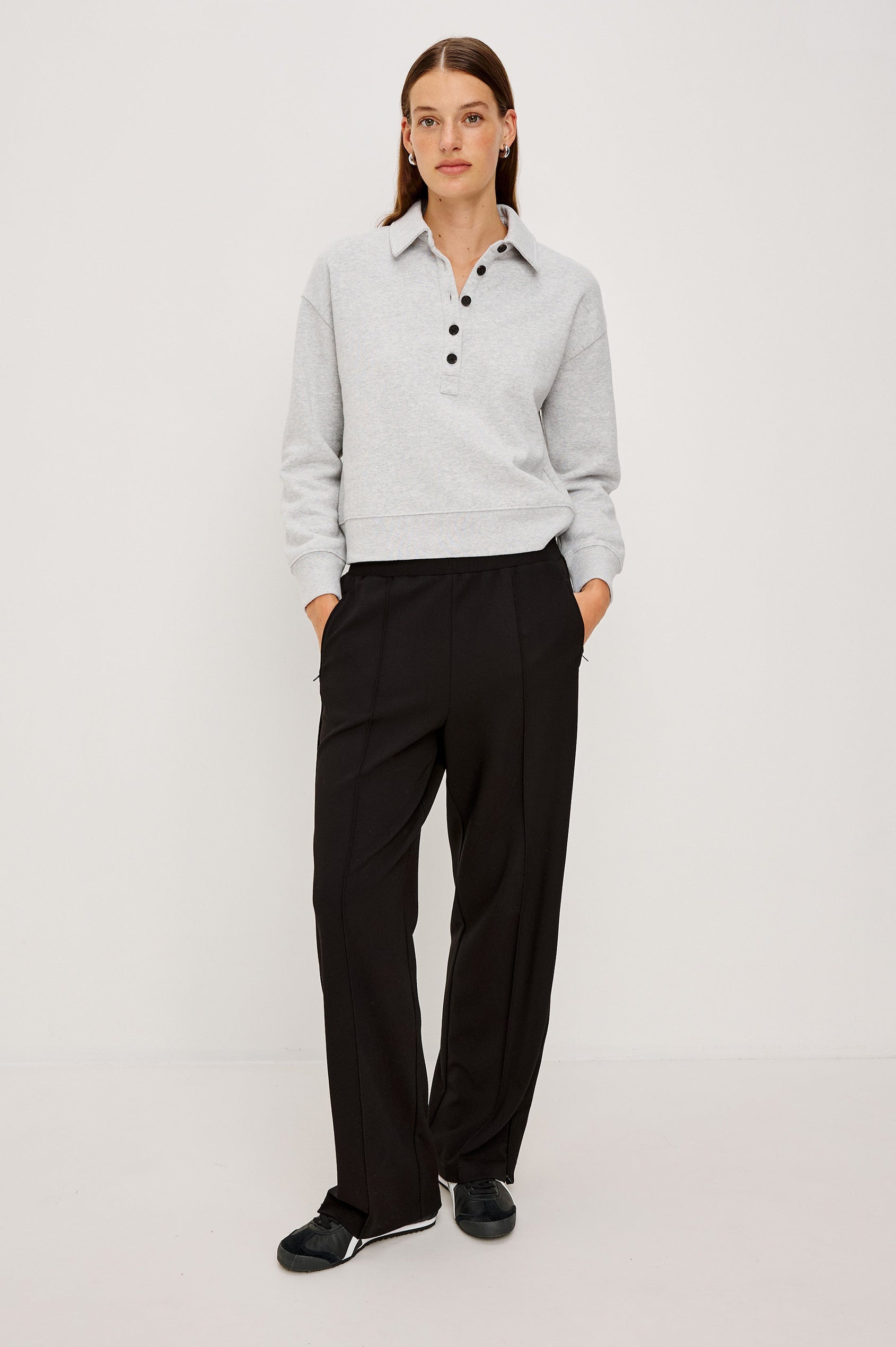 Cotton polo-style sweatshirt made from French terry fabric. The design features a button-front half placket, drop shoulders, and binding at the hem and cuffs for a relaxed, comfortable fit in Heather Grey Colorway - Full Body Front view featured on model 