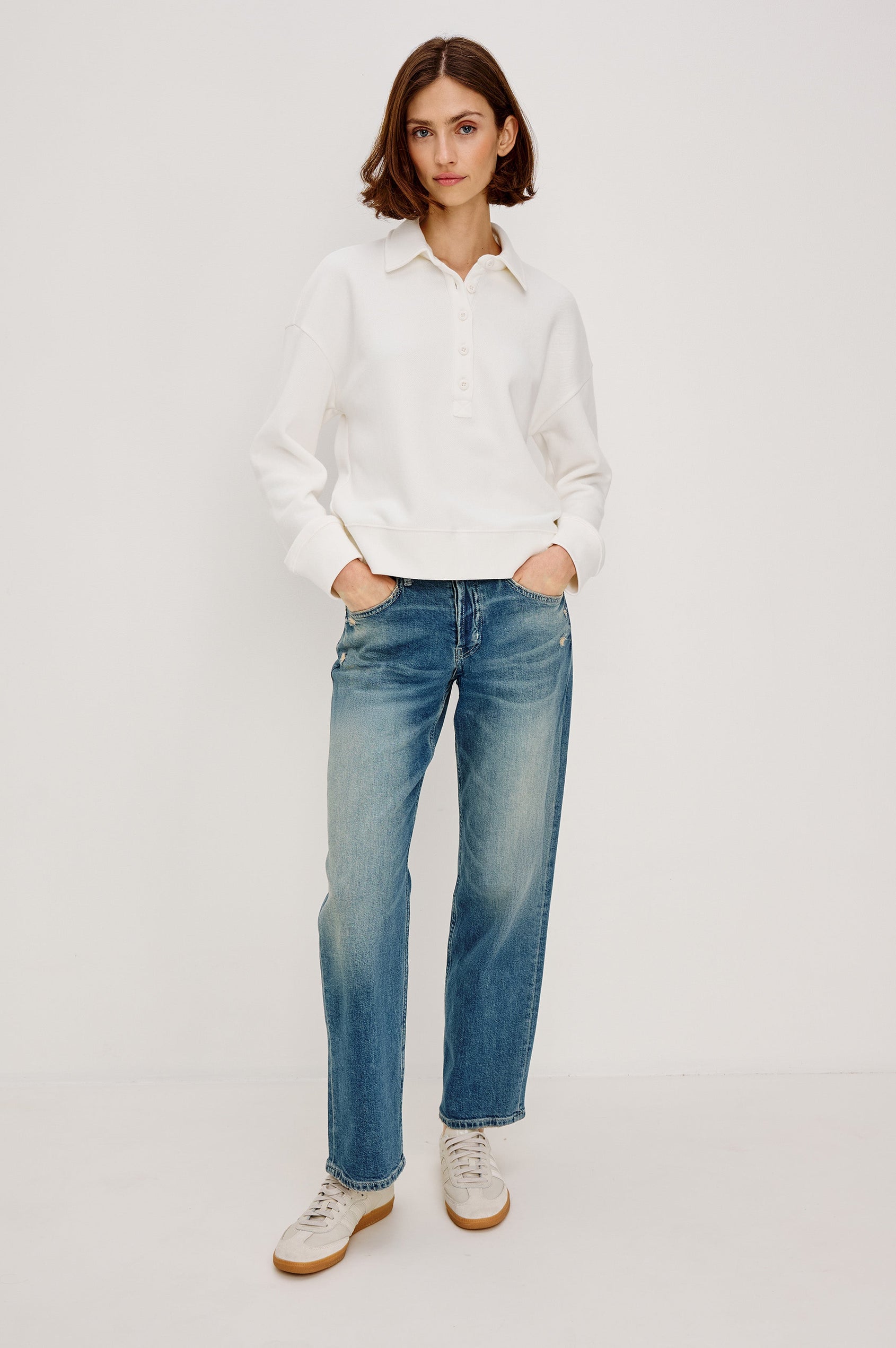 Cotton polo-style sweatshirt made from French terry fabric. The design features a button-front half placket, drop shoulders, and binding at the hem and cuffs for a relaxed, comfortable fit in Ivory Colorway - Full body Front view featured on model