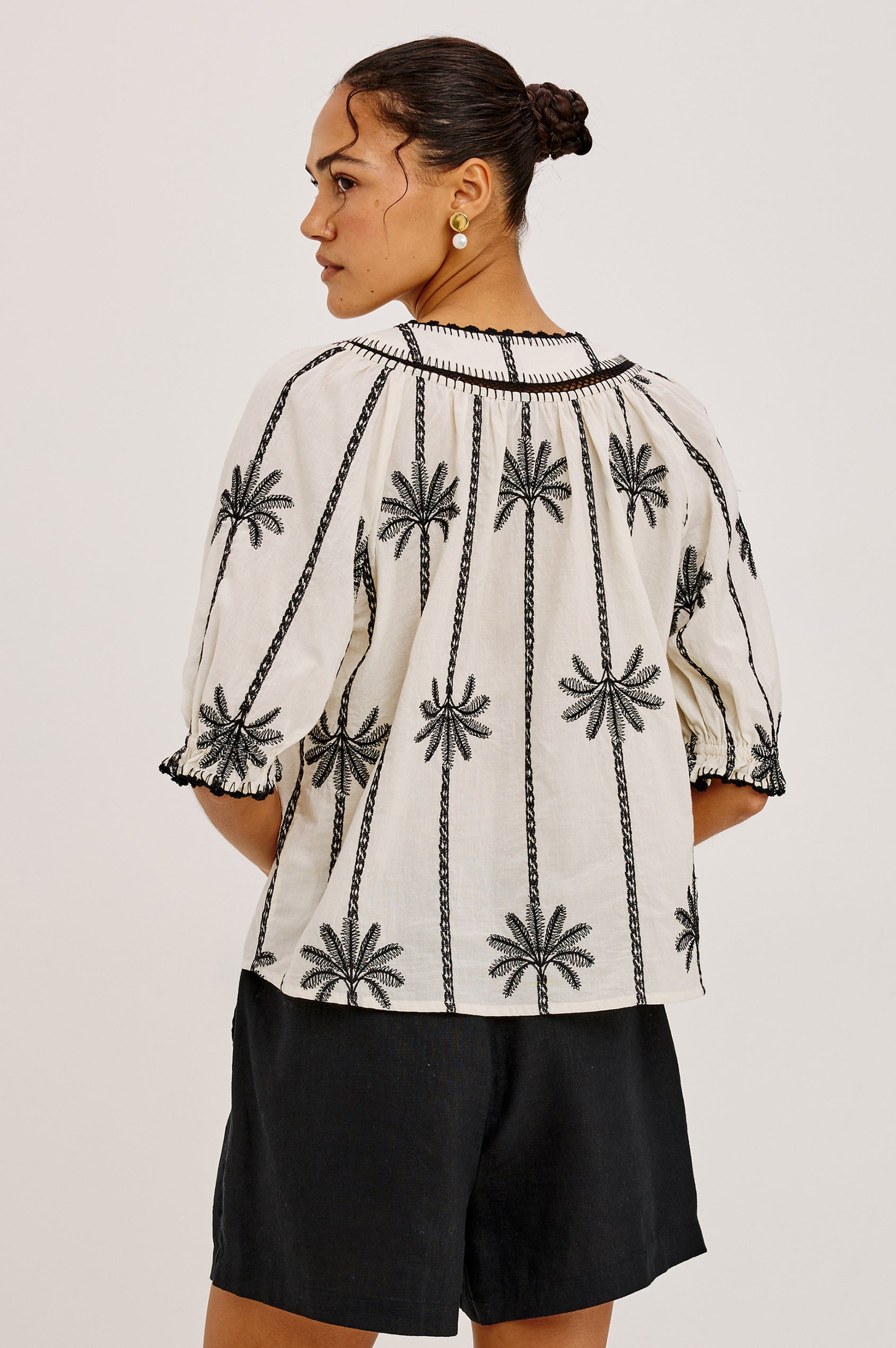 Belina Peasant Top in Cotton Voile With Gathered V-Neckline With Self Ties, Loose Fit, and Elbow-Length Puff Sleeves With Elastic Cuffs in Embroidered Palms Colorway - Upper Body Back View Featured on Model