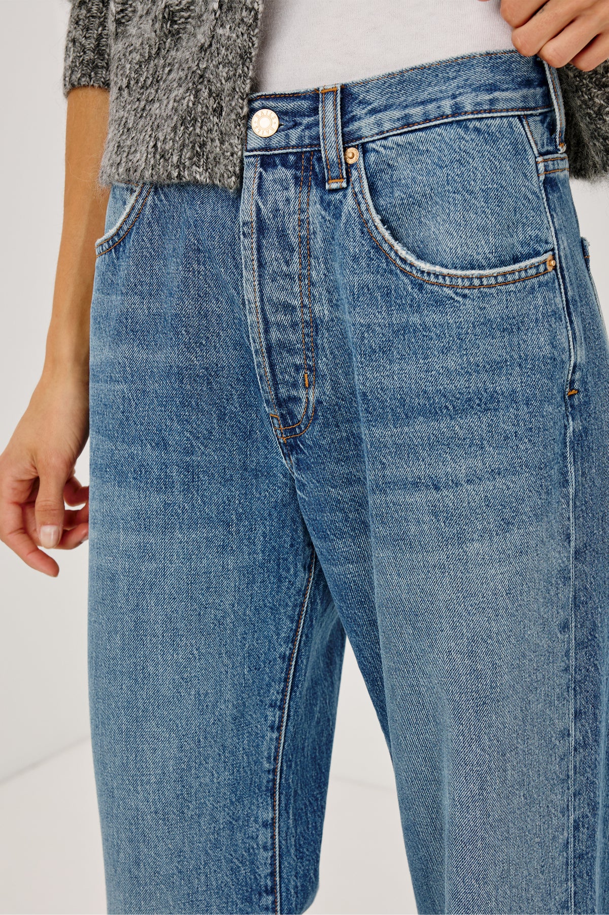 Belmont Arc Leg Jean in Rigid Denim With High Rise, Distressed Detailing, Button Fly, and 5-Pockets in Homestead Colorway - Close up view featured on model