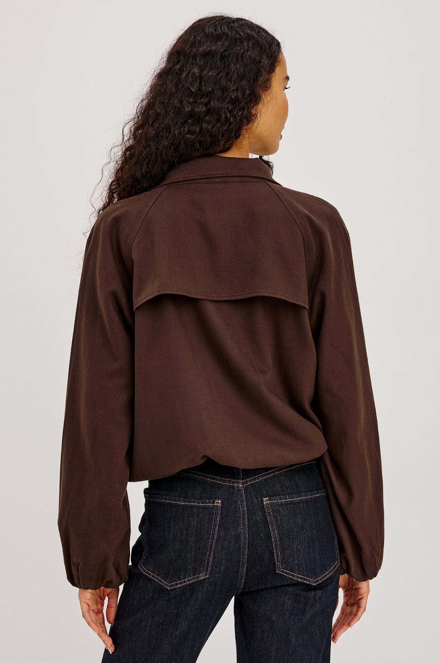 Blake Jacket in TENCEL™ Denim With Relaxed Fit, High Funnel Neck, Double Button Closures, Drop Shoulder Sleeves With Elastic Cuffs, and Cropped Drawstring Hem in Espresso Colorway - Upper Body Back View Featured on Model