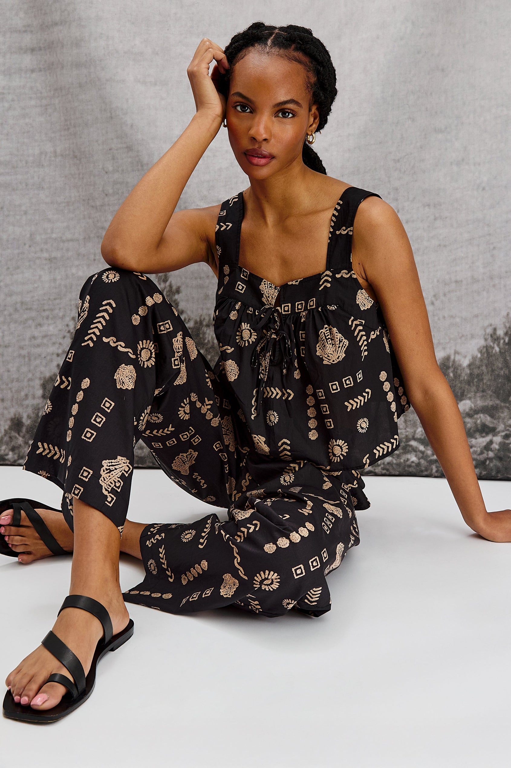 Blythe Square Neck Tank Top with Wide Straps and Two Front Ties in Beach Shells Colorway. Stylized View of Model Sitting.