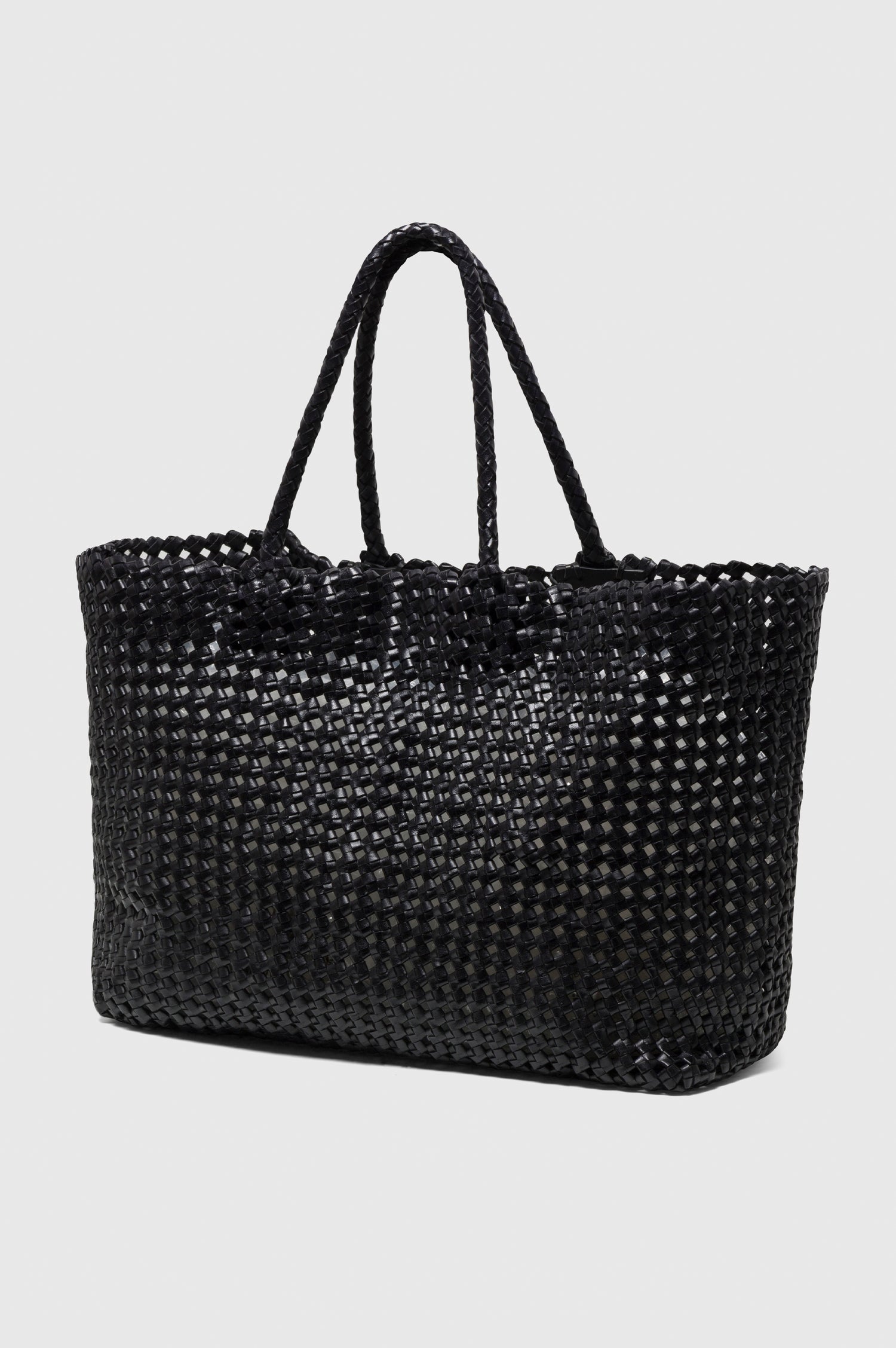 Brava Tote in Woven Leather With Top Handles and Spacious Interior in Black Colorway - angeled view off model