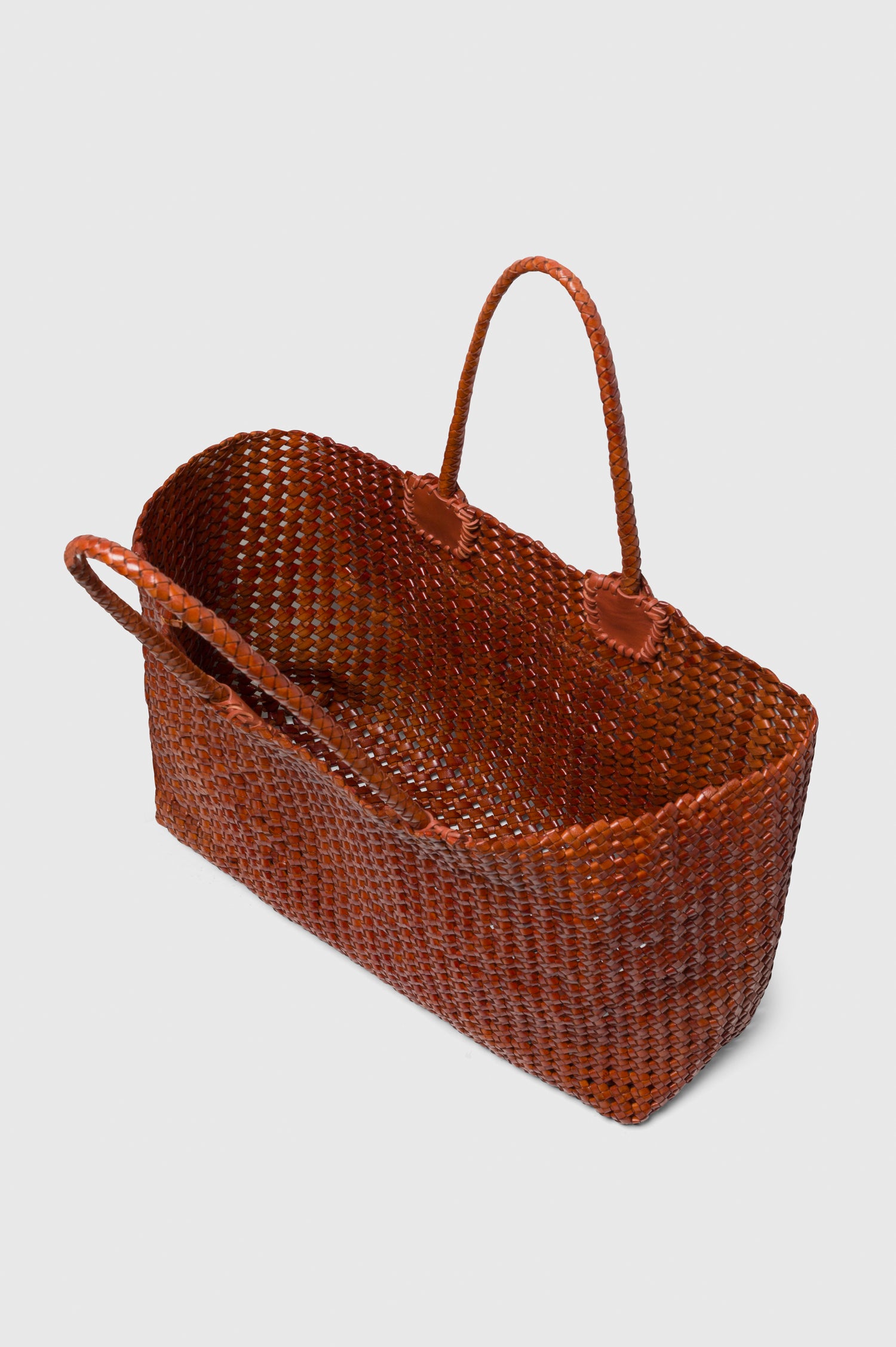Brava Tote in Woven Leather With Top Handles and Spacious Interior in Cognac Colorway - angled view, off model, opened.