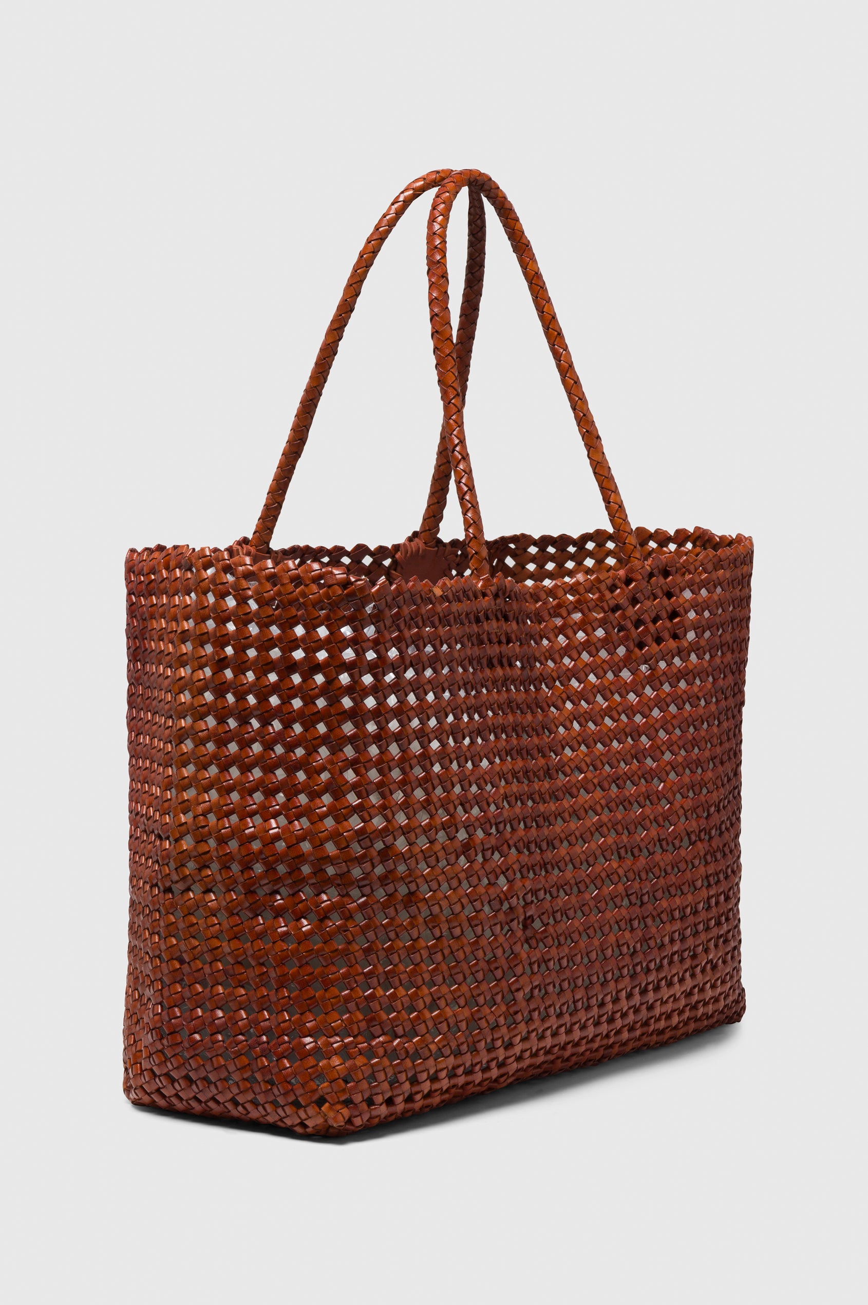 Brava Tote in Woven Leather With Top Handles and Spacious Interior in Cognac Colorway - side view, off model.