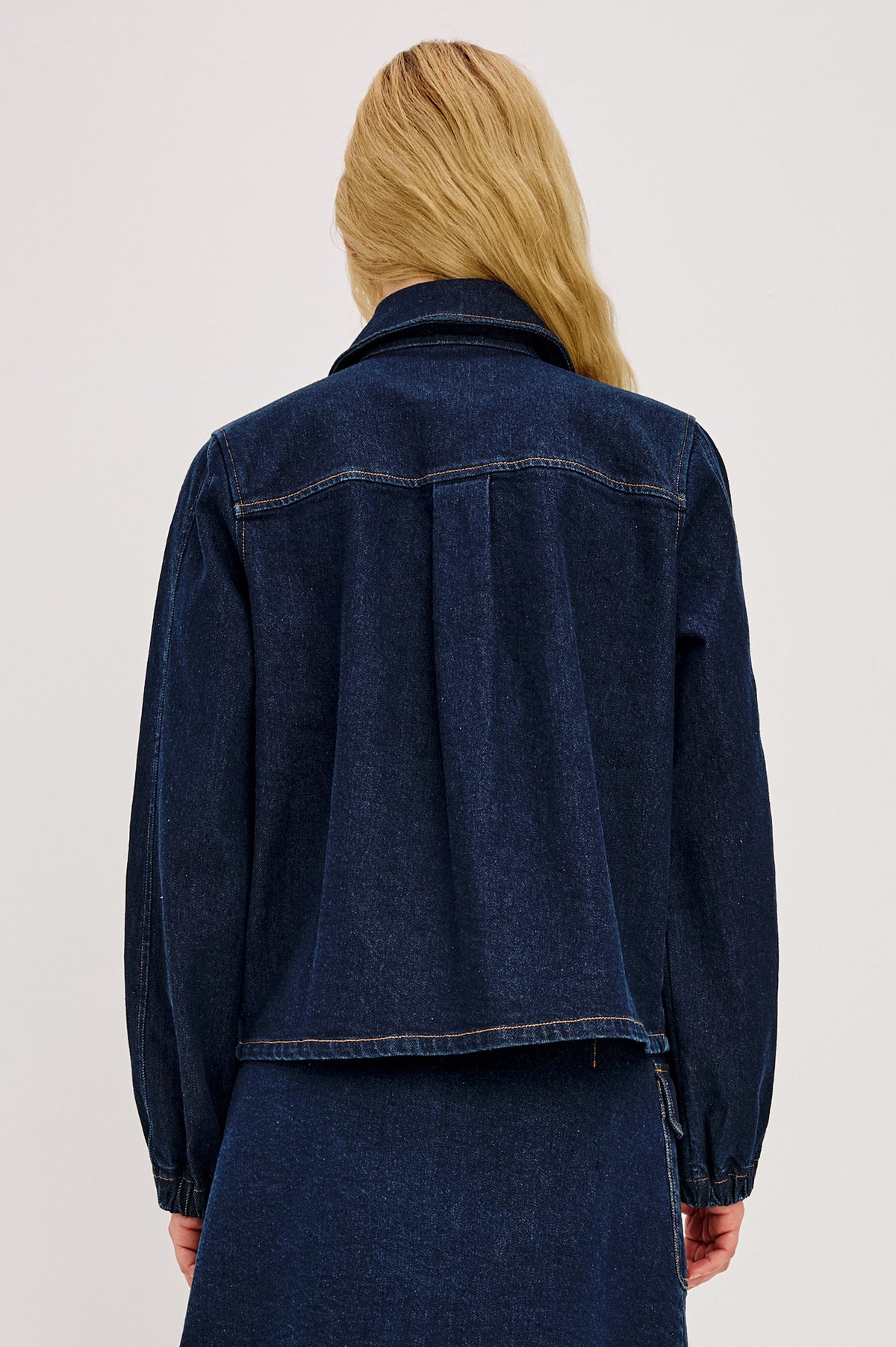Brooke Jacket in Midweight Denim With Duffel Slightly Cropped Fit, Long Balloon Sleeves, Elastic Cuffs, Back Yoke Pleat, and Front Toggle Closures in Rinse Indigo Colorway - Upper Body Back View Featured on Model