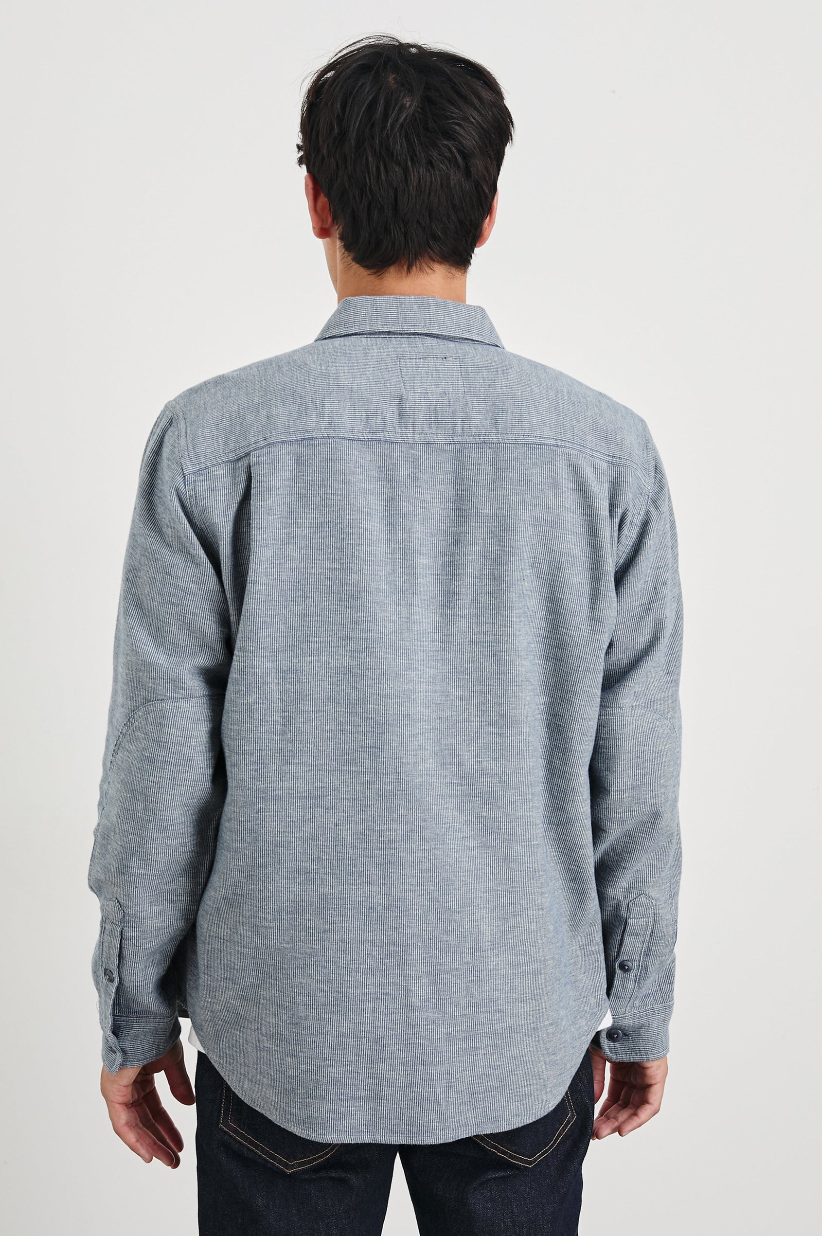 Burr Collared Shirt Jacket with Button Closure, Two Chest Button Flap Pockets and Textured Fabric in Denim White Colorway - Back Unbuttoned View Featured on Model