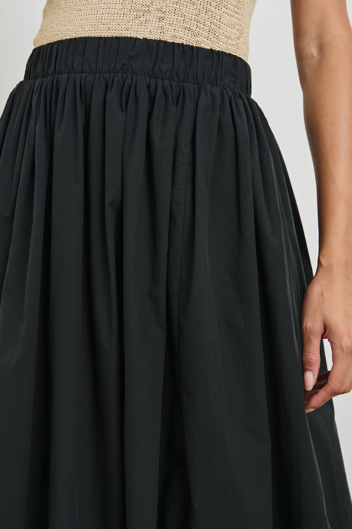 Cala midi length bubble skirt with elastic waistband and side pockets in Black - close up of waist details on model