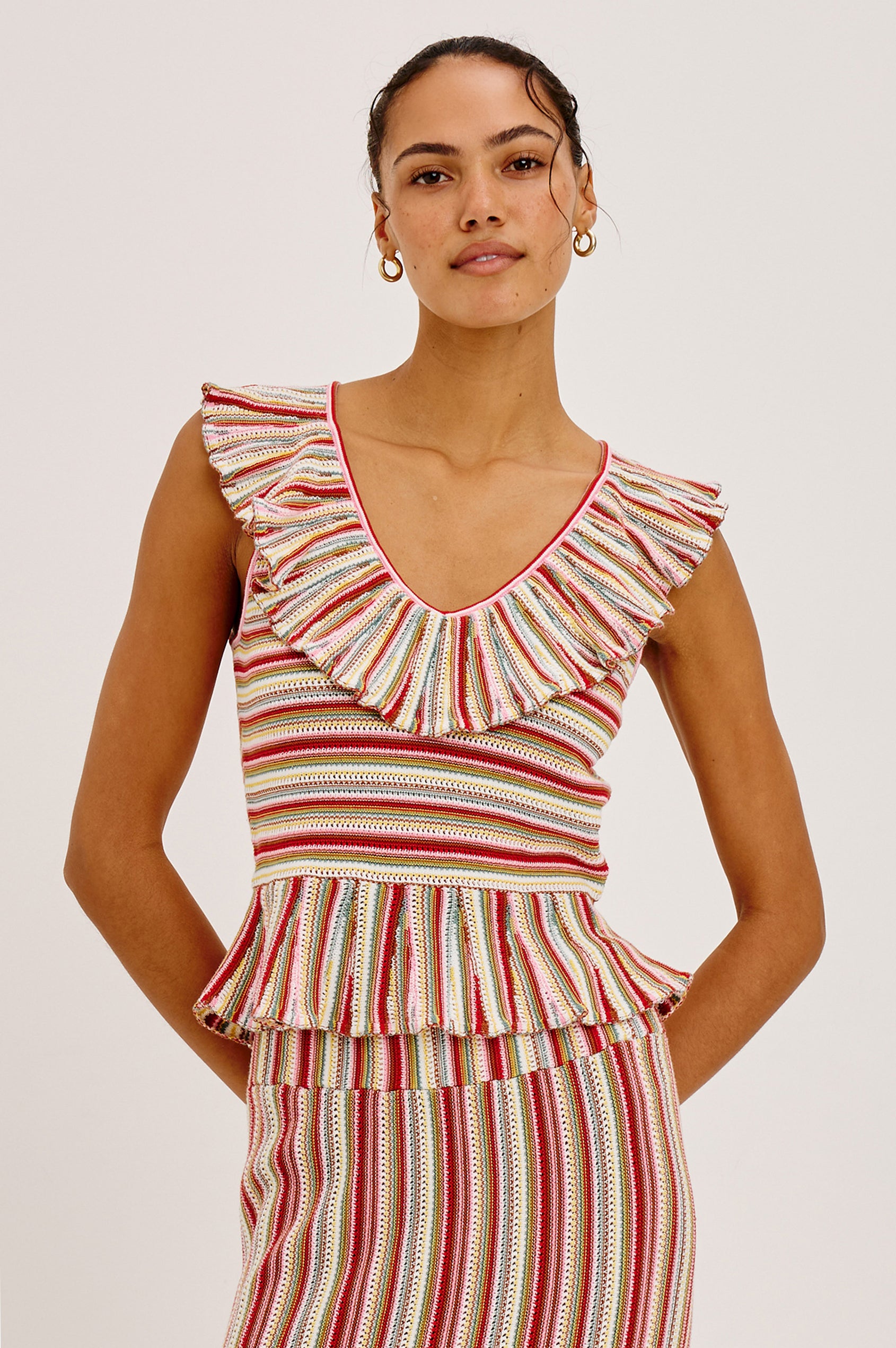 Carmelita Crop Top in Crochet Knit With Ruffle V-Neckline, Fitted Bodice, and Peplum Hem in Havana Stripe Colorway - Upper Body Front View Featured on Model