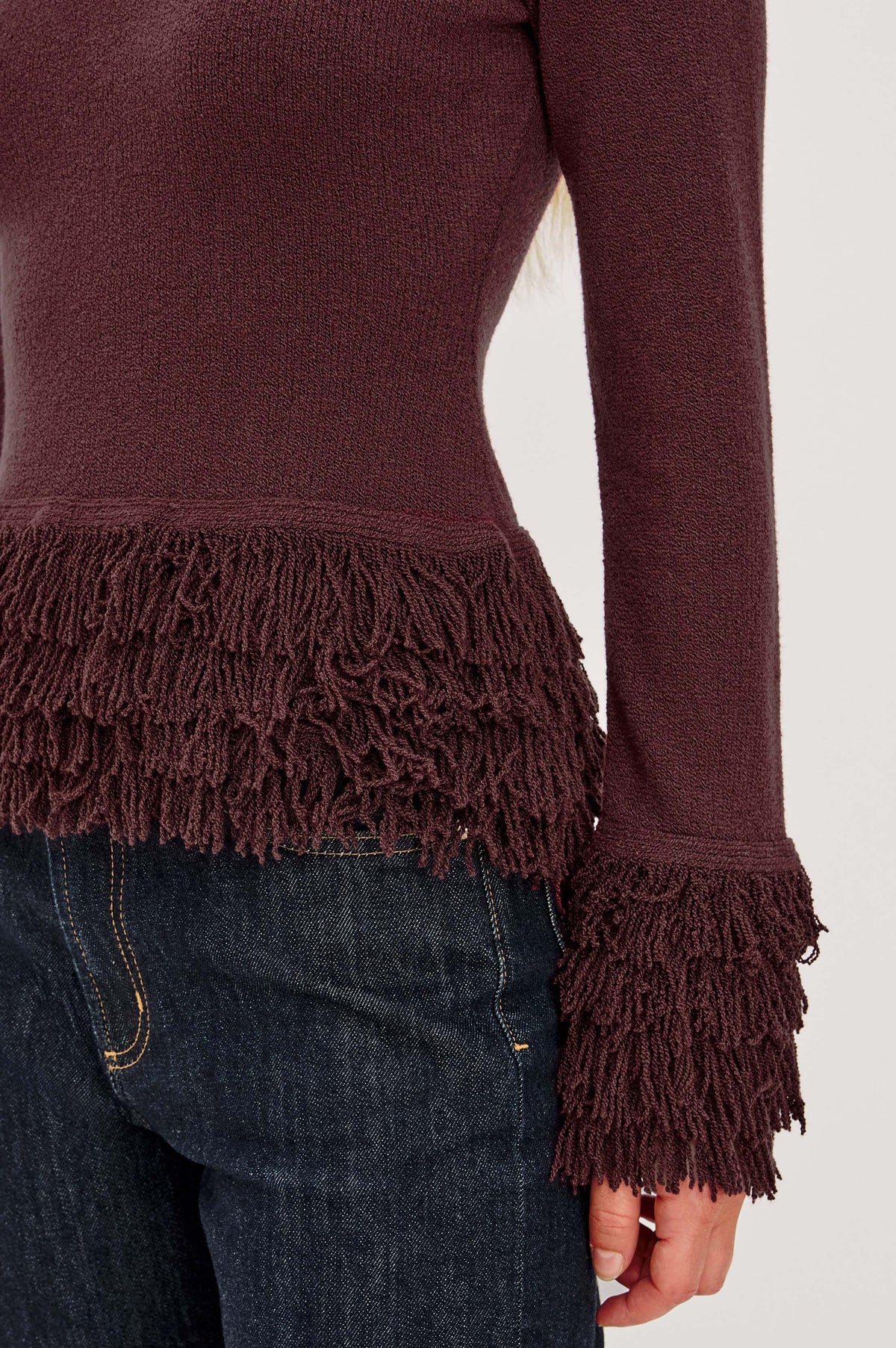 Carmen Sweater in Ribbed Knit With Fringe Trim Hem and Cuffs, Crew Neck, and Long Sleeves in Wine Colorway - Upper Body Front Detail View Featured on Model.