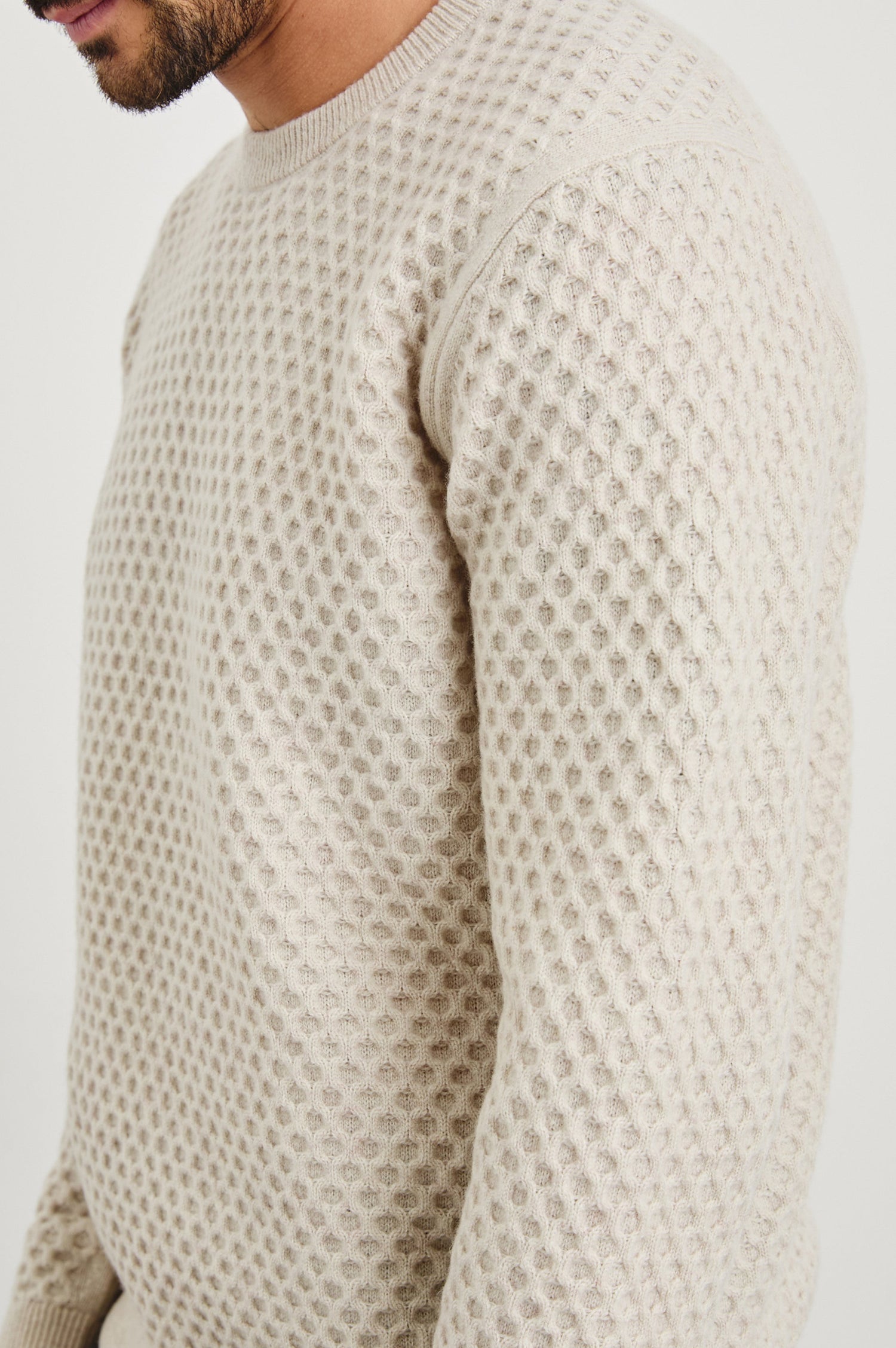 Carrick Long-Sleeve Sweater with a Crew Neck, Honeycomb Stitch, and Ribbed Trim in Oatmeal Heather Colorway - Side View Featured on Model