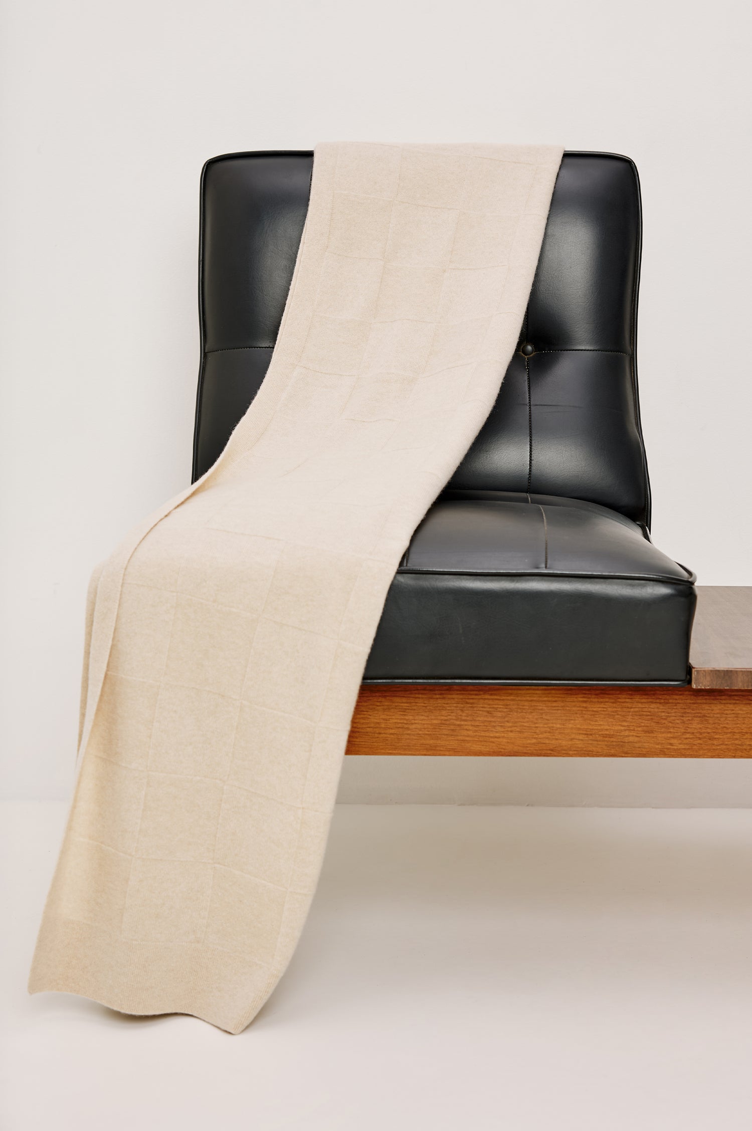 Cashmere throw in creme colorway. Draped on a chair.