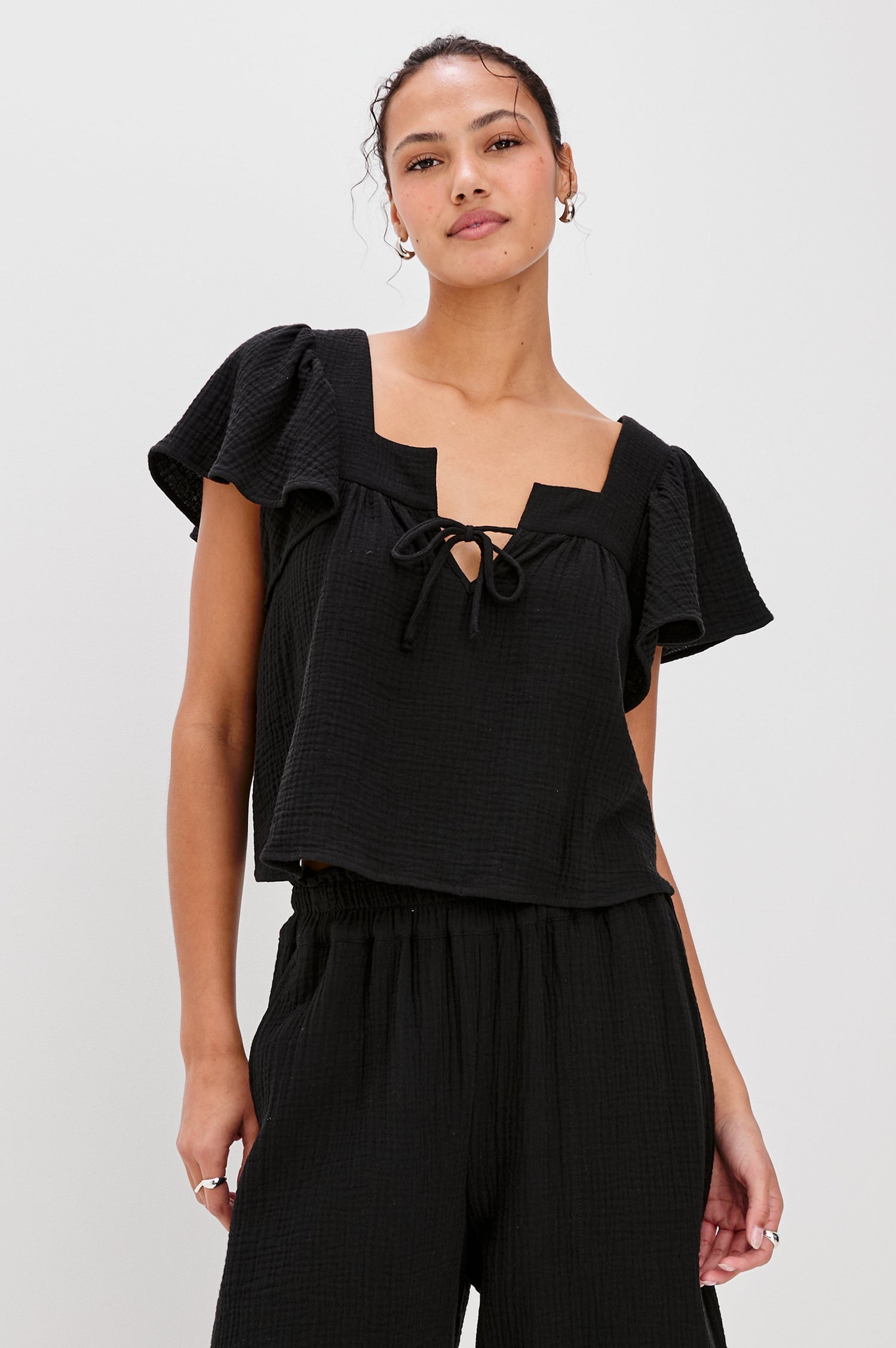 Casie Square Neck Top with Short Flutter Sleeves, V-Cut Center Front with Self Tie in Black Colorway. Front View Shown on Model.