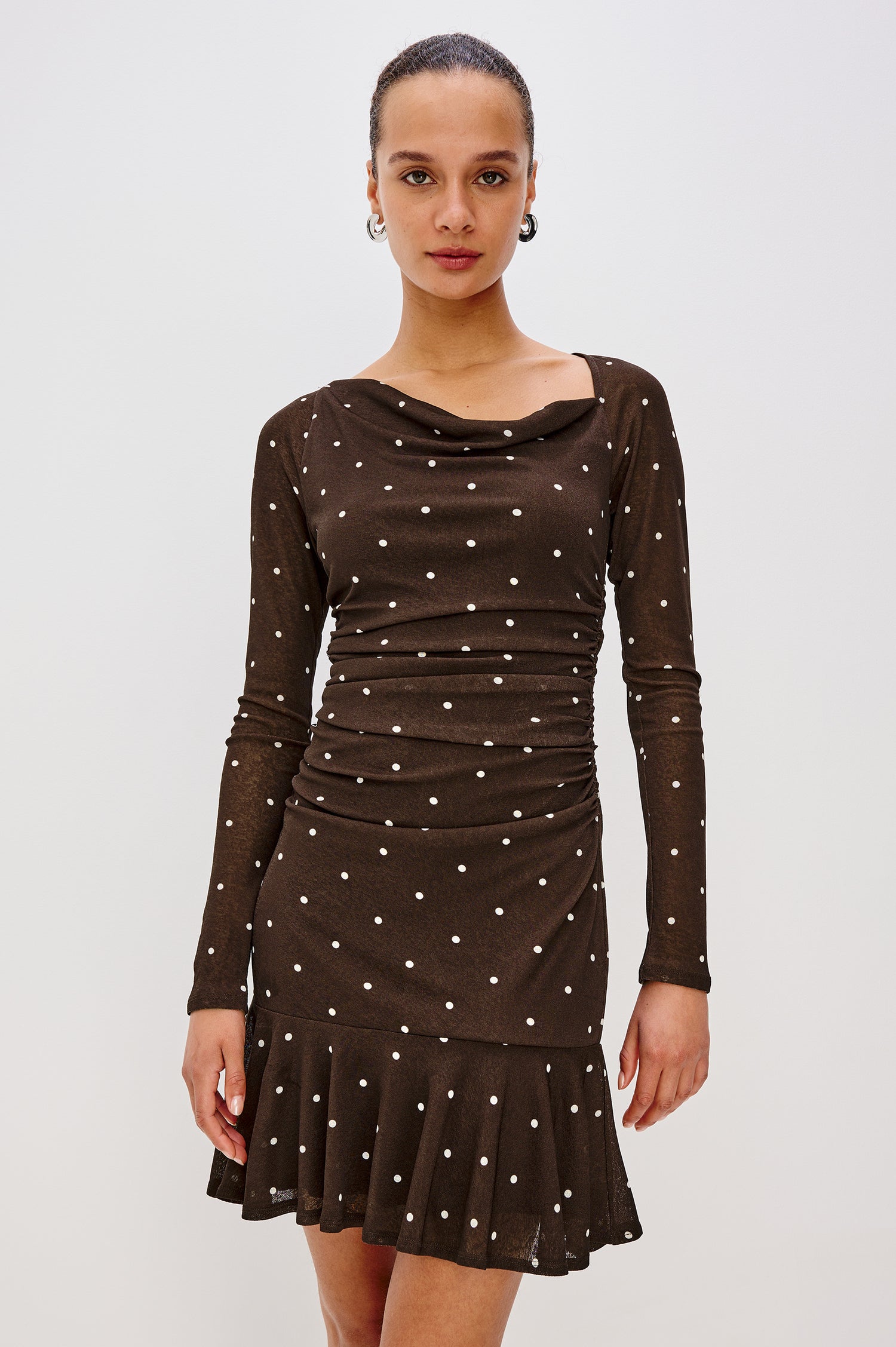 Celano Mini Dress in Mesh With Asymmetrical Cowl Neckline, Long Raglan Sleeves, Waist Shirring, Bias Cut Skirt in Cocoa Polka Dots Colorway - Front Full Body View Featured on Model