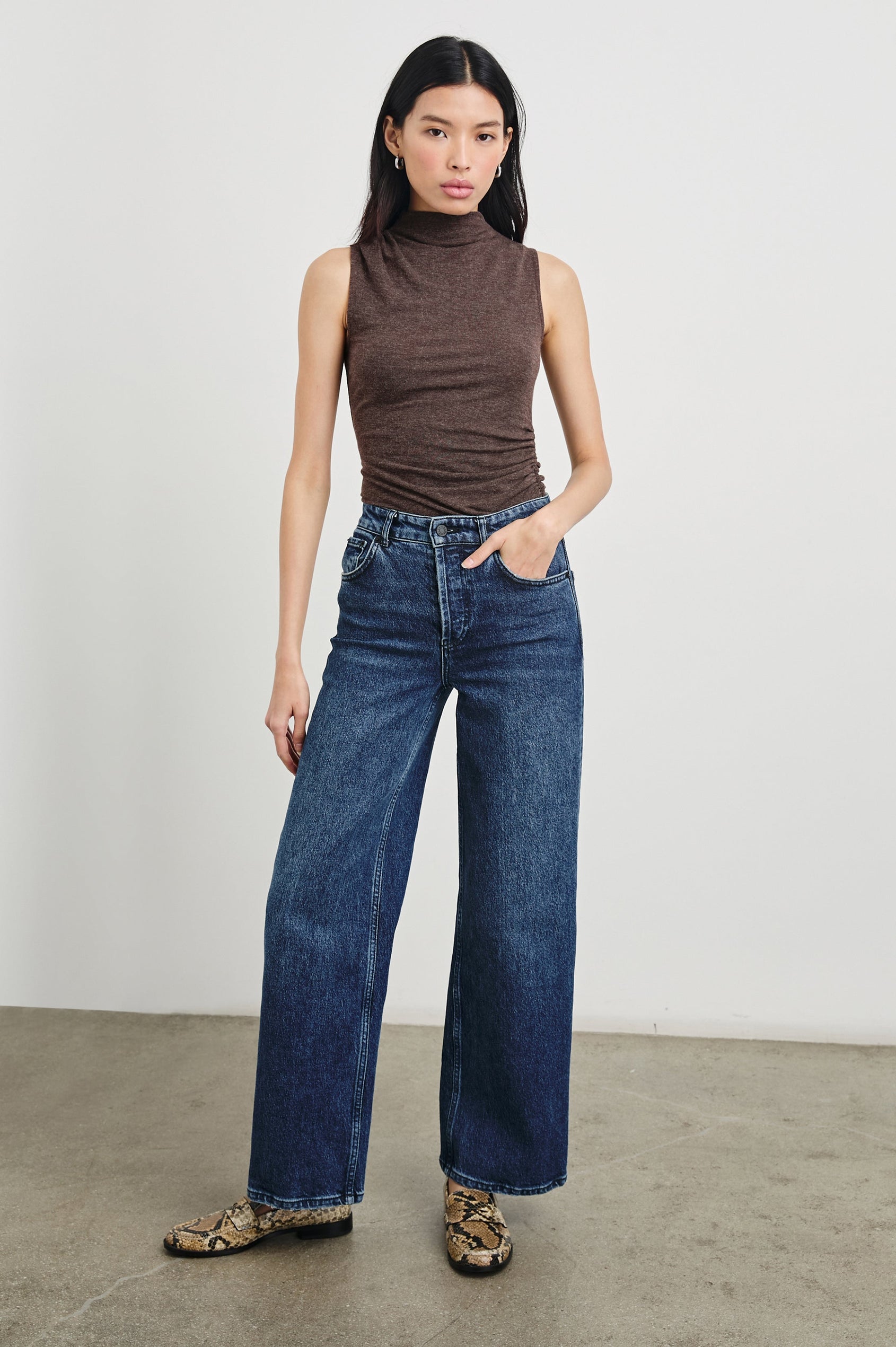 Christen Sleeveless Top with a Mock Neck and Ruching Along One Side Seam in Heather Brown Colorway - Front Full Body View Featured on Model
