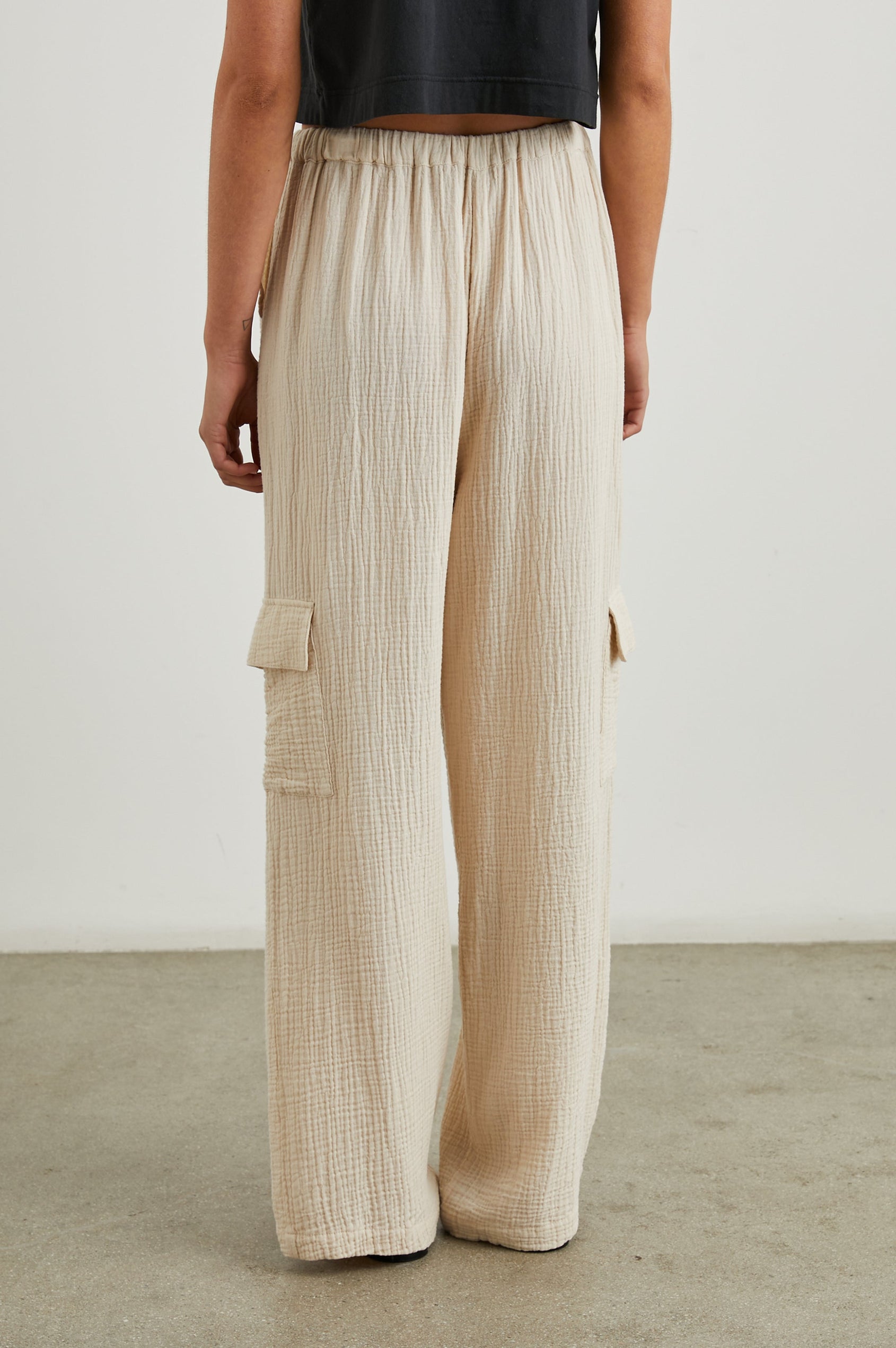 Christiano Pants with a Drawstring Waist, Two Front Pockets and Two Flap Side Pockets in Flax Colorway - Back View Featured on Model  