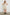 Cindy Above-Knee Sleeveless Dress with Buttons down the Bodice, a Cinched Waist, and a Tiered Skirt in Ivory Zanzibar Colorway, a Black Grid on Ivory - Front Full Body View Featured on Model