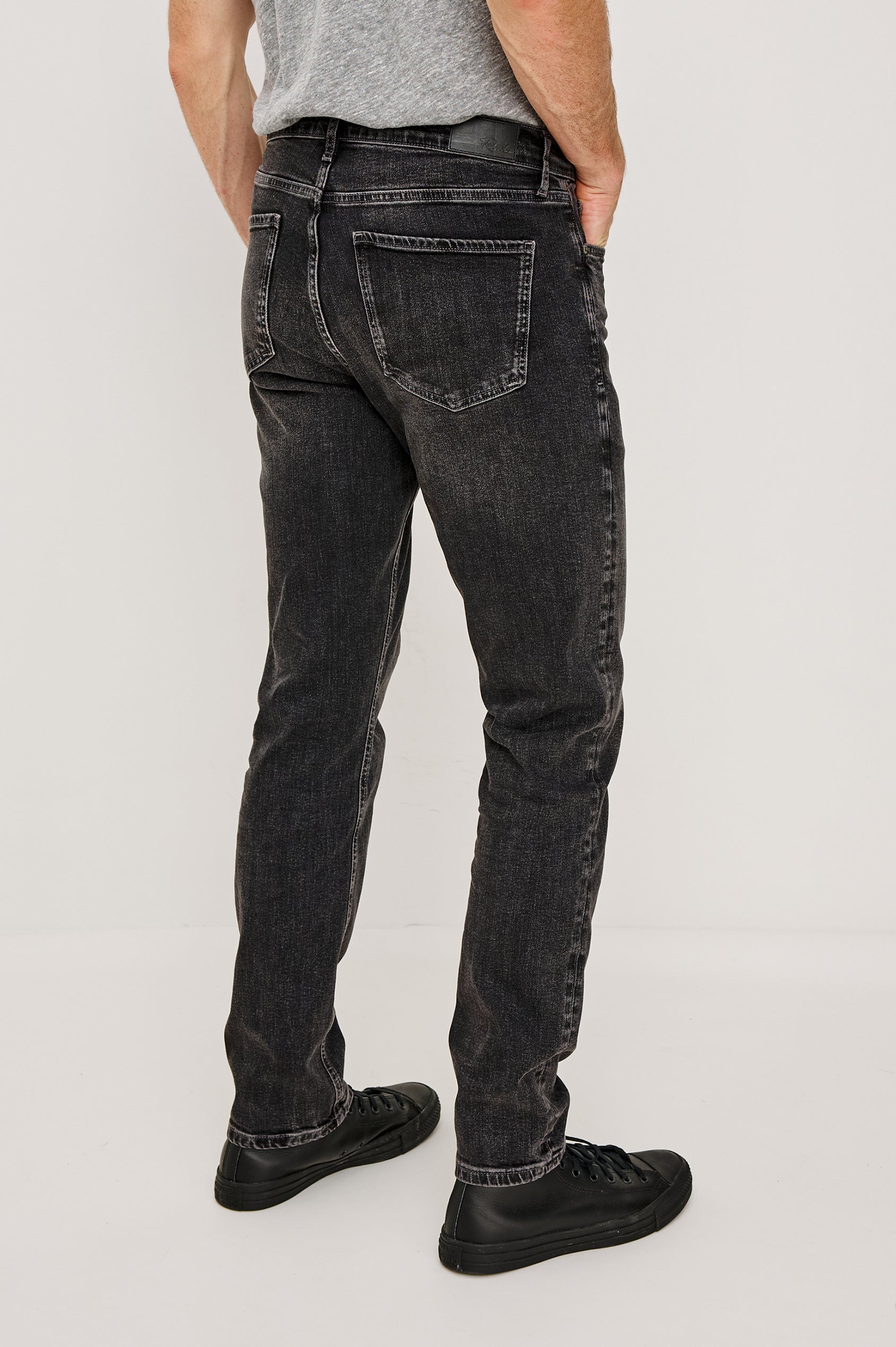 Clayton Slim Straight Jean With 5-Pocket Styling, Belt Loops, and Front Zip-Fly in Faded Onyx Black Colorway - Lower Body Back View Featured on Model