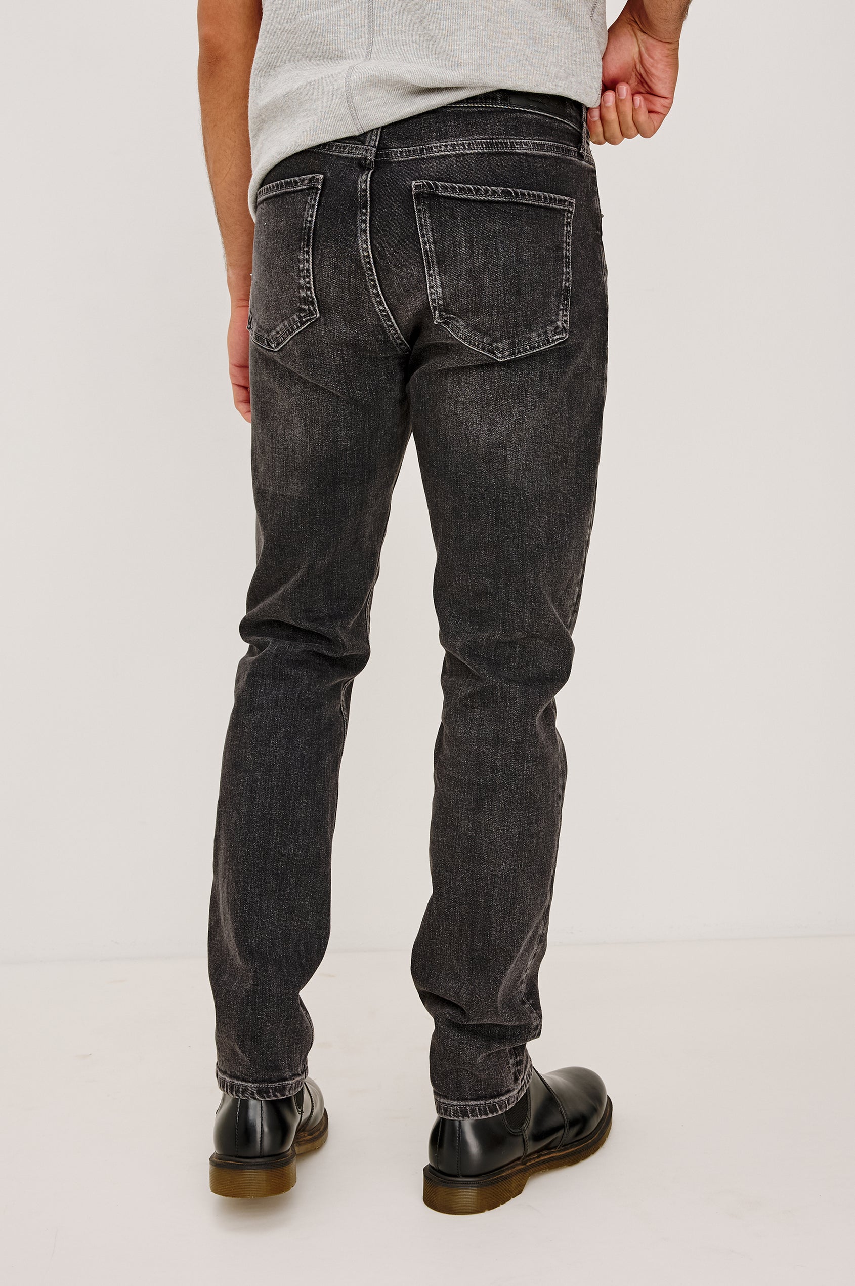 Clayton Slim Straight Jean With 5-Pocket Styling, Belt Loops, and Front Zip-Fly in Faded Onyx Colorway - Lower Body Back View Featured on Model