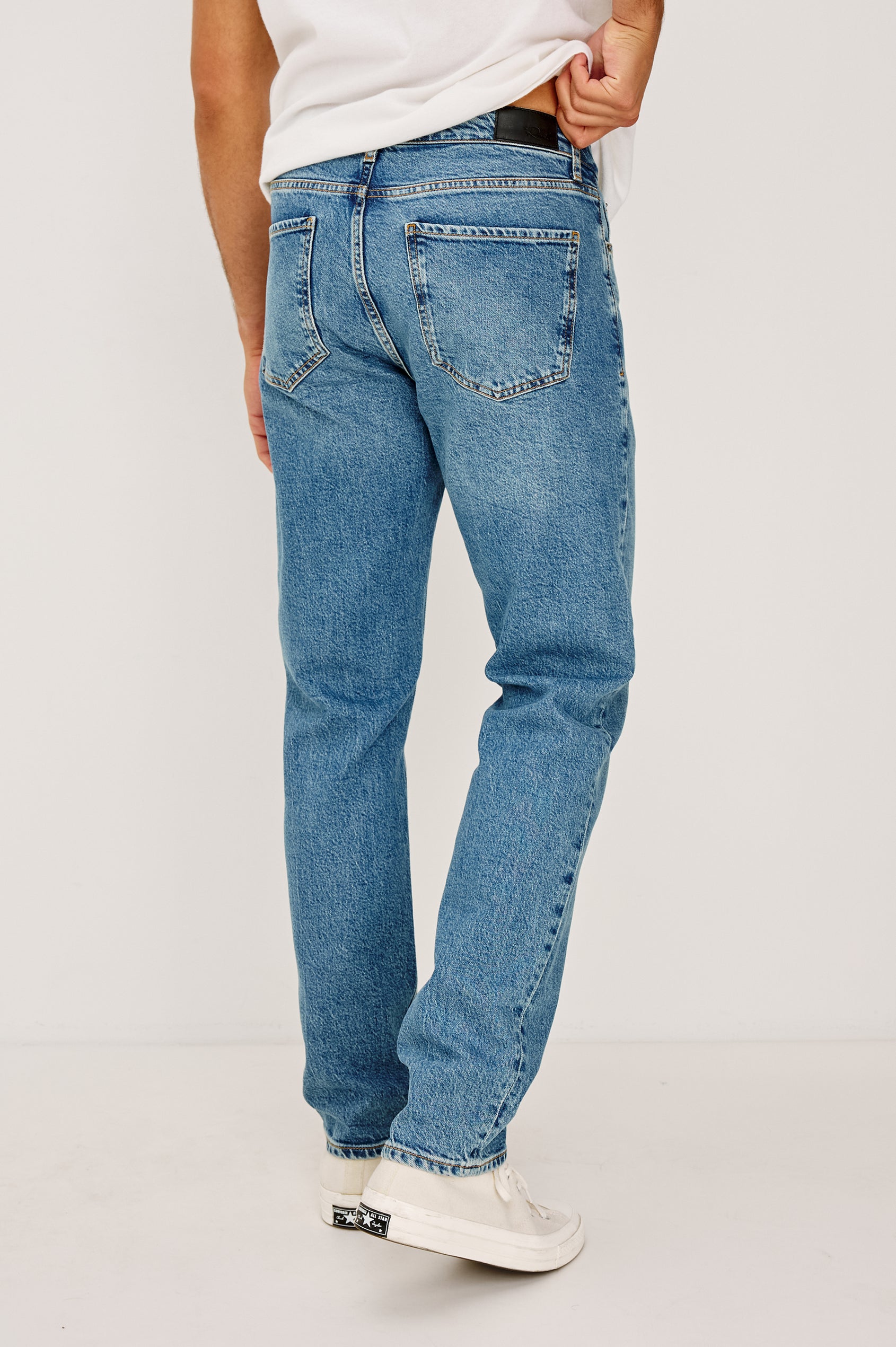 Clayton Slim Straight is a Classic 5-Pocket Jean in Heritage Indigo Colorway, a Medium Blue Wash. Back View Featured on Model.