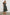 Clementine Midi Dress with a Deep V Neckline, Flutter Sleeves, Smocked Top and Two Side Pockets in Dark Amaryllis Colorway, Yellow and Green flowers on Black - Front Full Body View Featured on Model