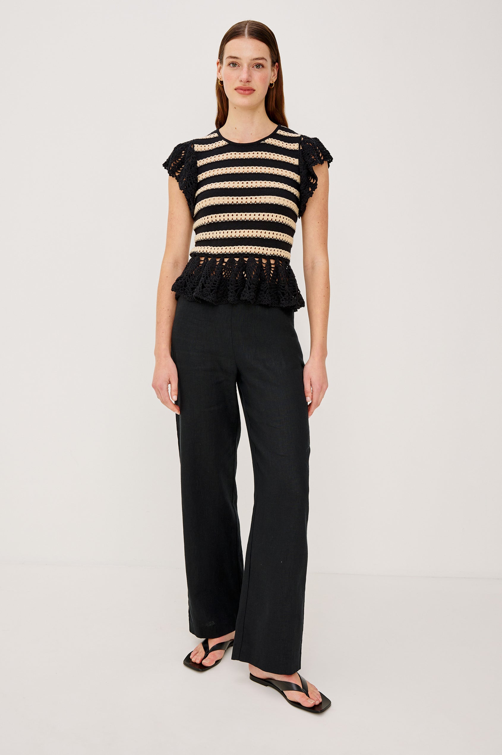 Coen Top in Cotton Blend Crochet With Crew Neckline Eyelet Detailing Flutter Sleeves Pepplum Hem and Back Keyhole With Adjustable Ties in Black Oat Stripe Colorway - Full Body Front View Featured on Model
