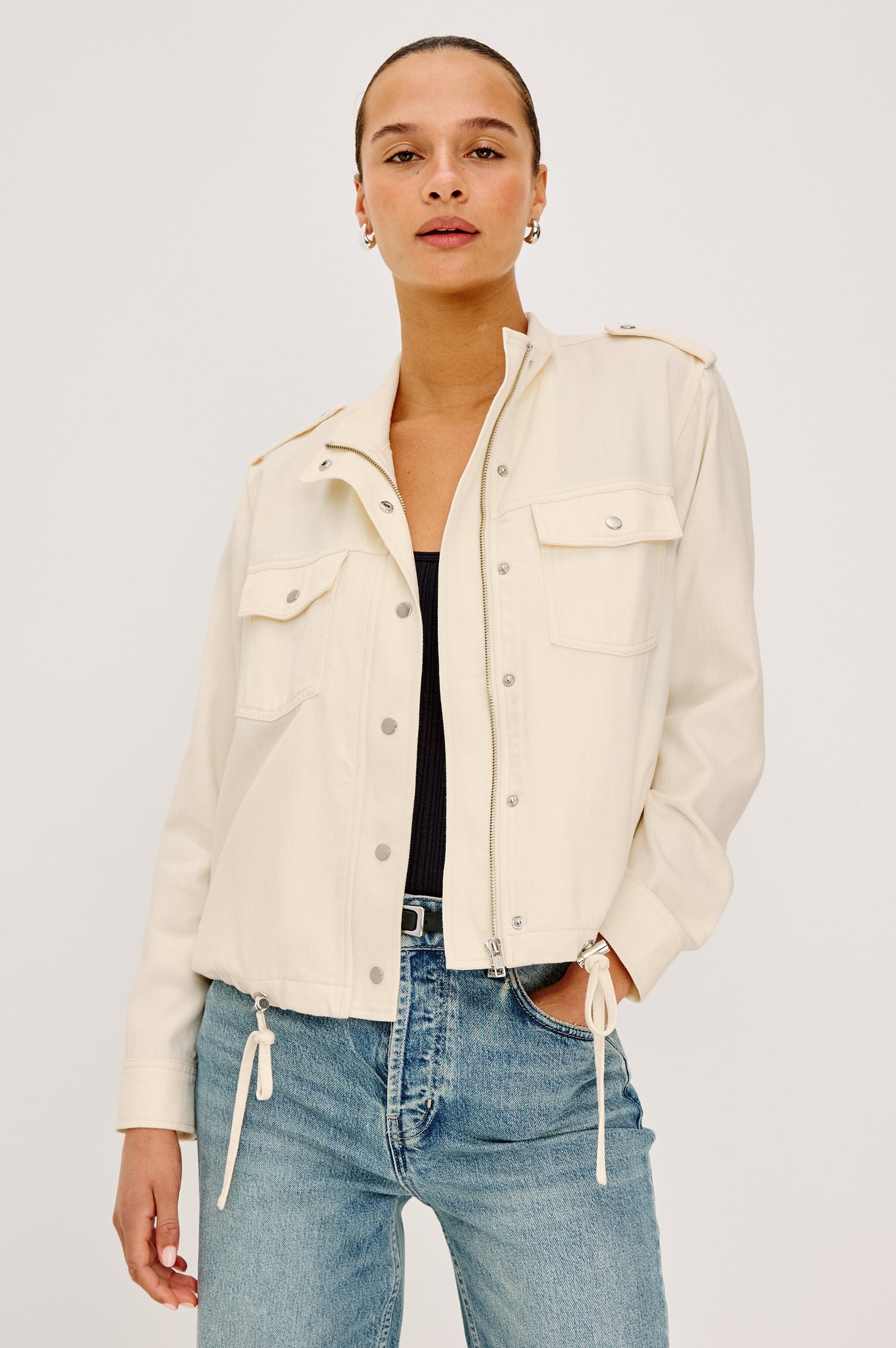 Collins Miitary Inspired Jacket With Shoulder Epaluettes, Stand Collar, Front Snap Buttons, Double Chest Pockets, Long Sleeves in Ivory Colorway - Upper Body Front View Featuered on Model