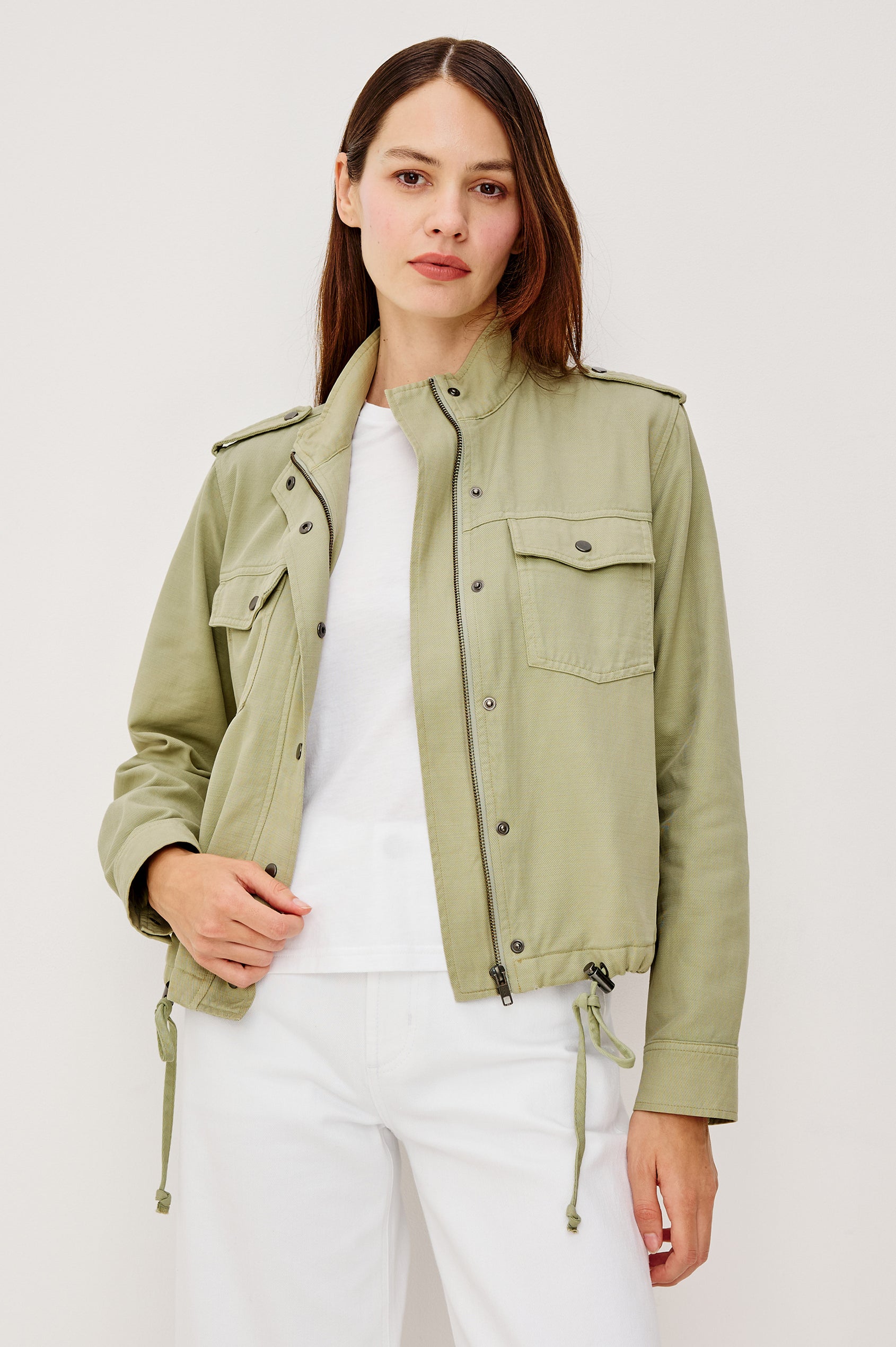 Collins Miitary Inspired Jacket With Shoulder Epaluettes Stand Collar Front Snap Buttons Double Chest Pockets Long Sleeves in Vintage Sage Colorway - Upper Body View Featuered on Model