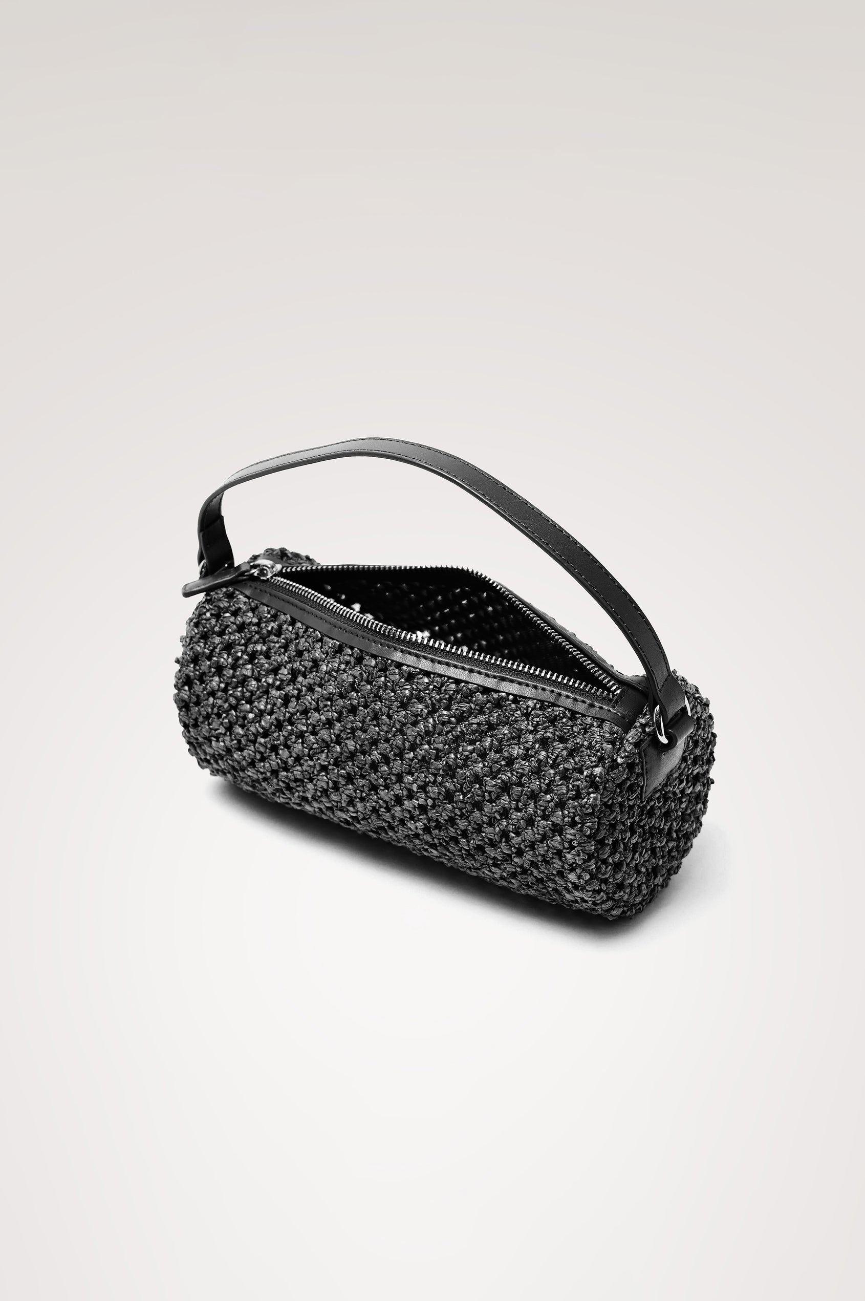 Como Mini Barrel Bag in Woven Raffia With Top Strap, Removable and Adjustable Crossbody Strap, and Top Zip in Black Raffia Colorway - Top View Featured