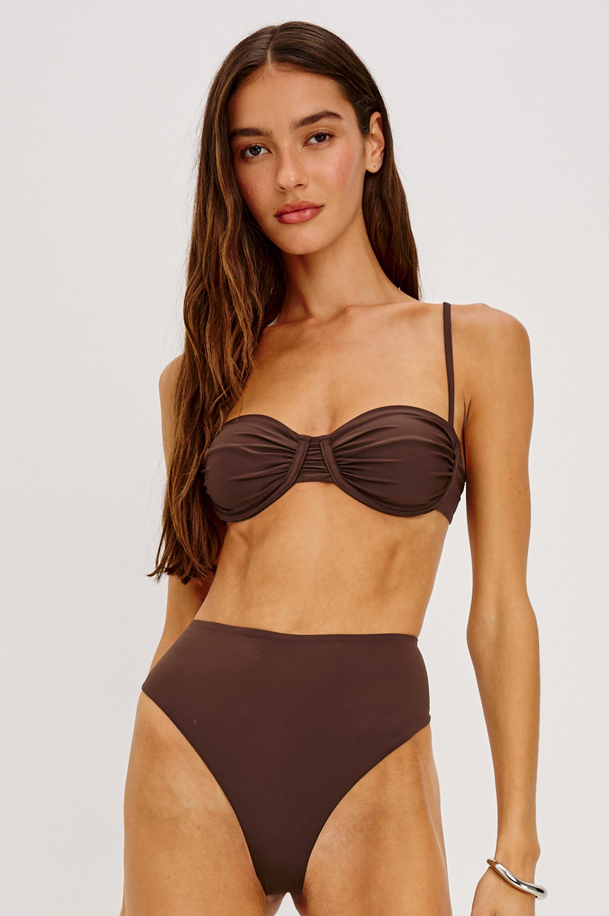 Concha Bikini Top With Balconette Shape, Ruched Underwire Bust Cups, Adjustable Shoulder Straps, and Back Hook Closure in Espresso Colorway - Upper Body Front View Featured on Model Sitting