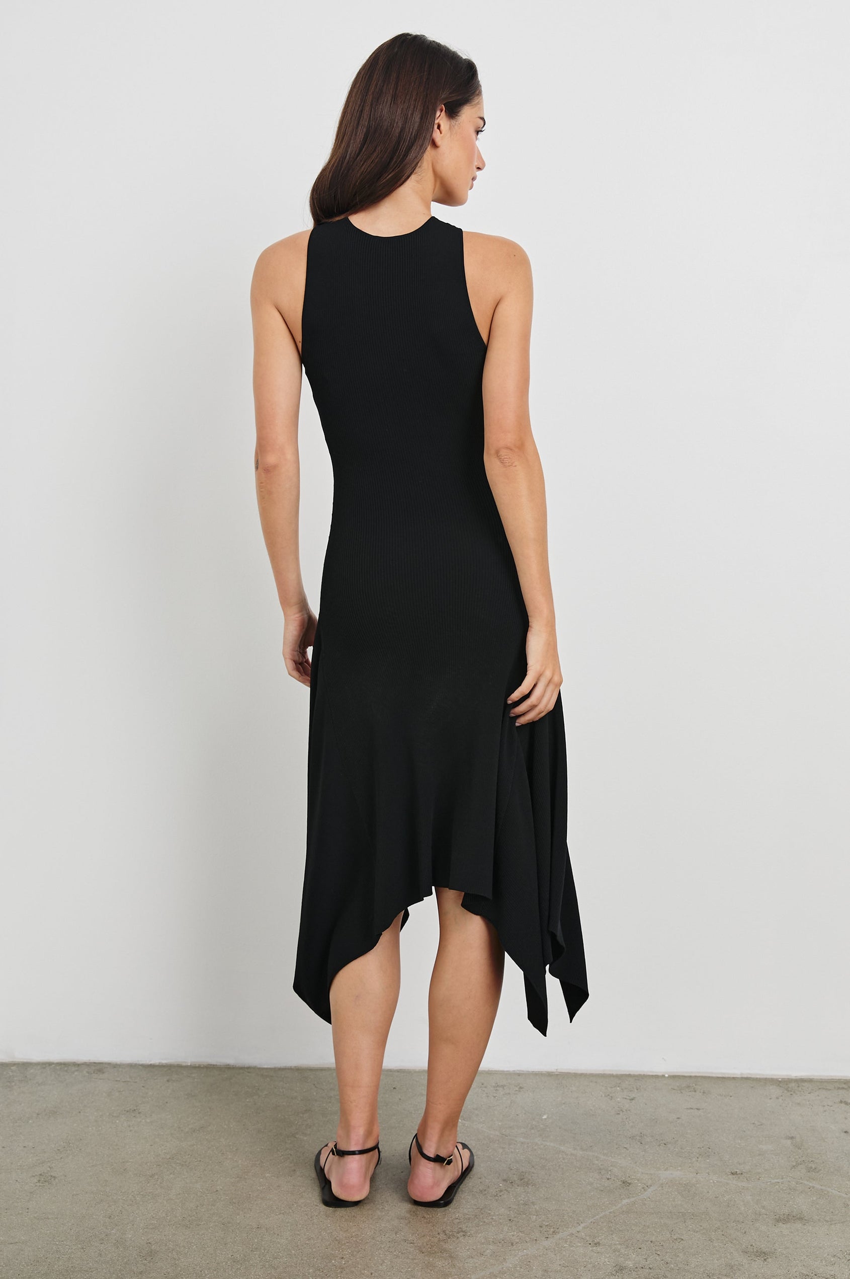 Constanze Midi Halter Dress with a Asymmetrical Hem, Gold Sea Shell Hardware at Neck in Black Colorway. Full Body Back View Shown on Model.