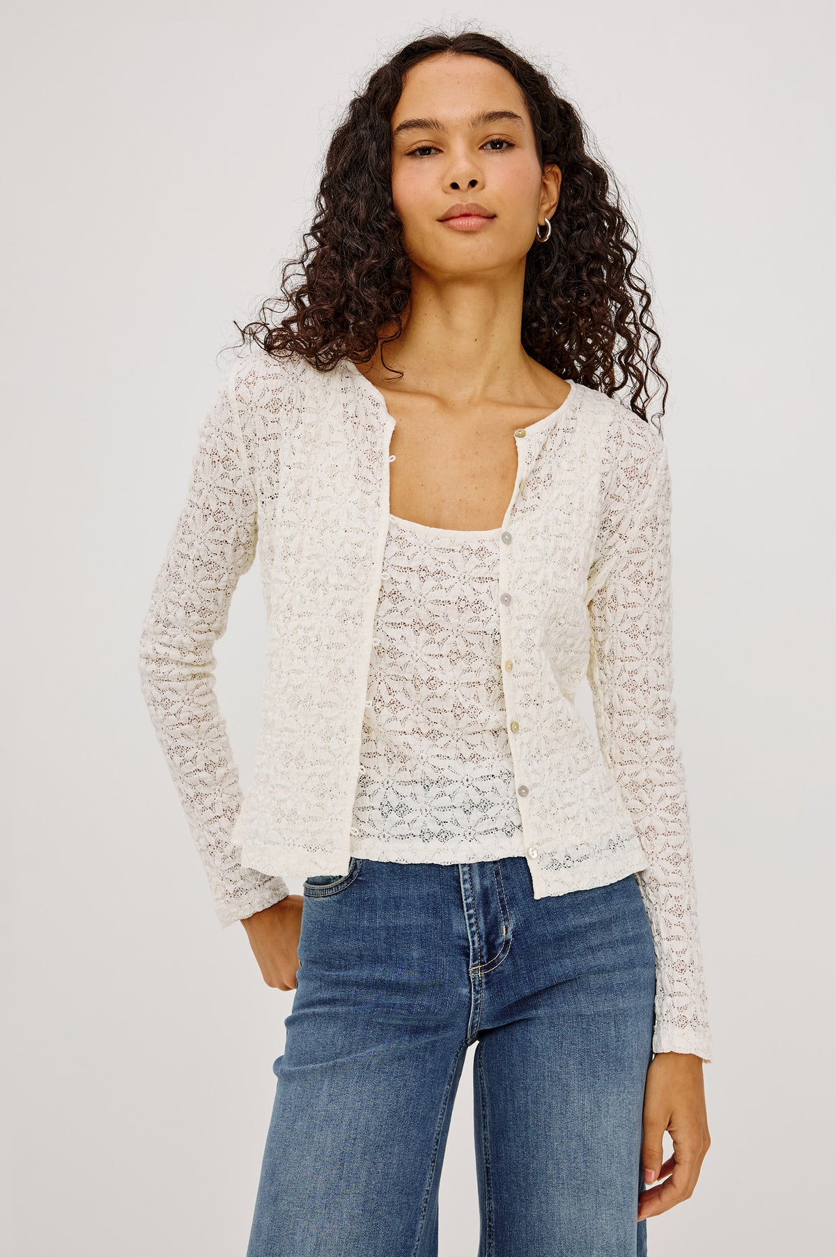 Cyrah Top in Sheer Stretch Lace With Long Sleeves, Front Button-and-Loop Closures, Crew Neckline, and Fitted Silhouette in Ivory Colorway - Upper Body Front View Featured on Model