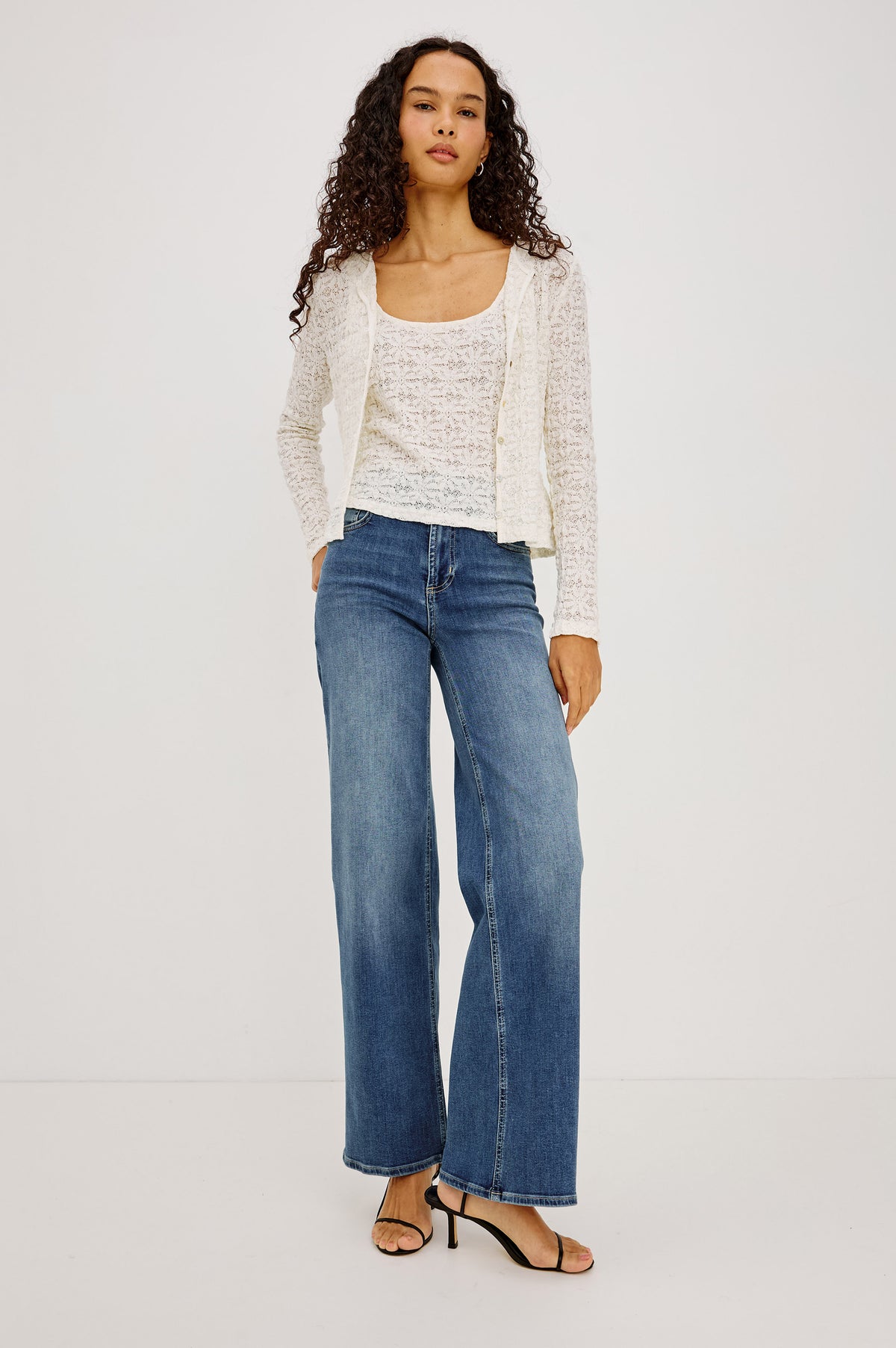 Cyrah Top in Sheer Stretch Lace With Long Sleeves, Front Button-and-Loop Closures, Crew Neckline, and Fitted Silhouette in Ivory Colorway - Full Body Front View Featured on Model