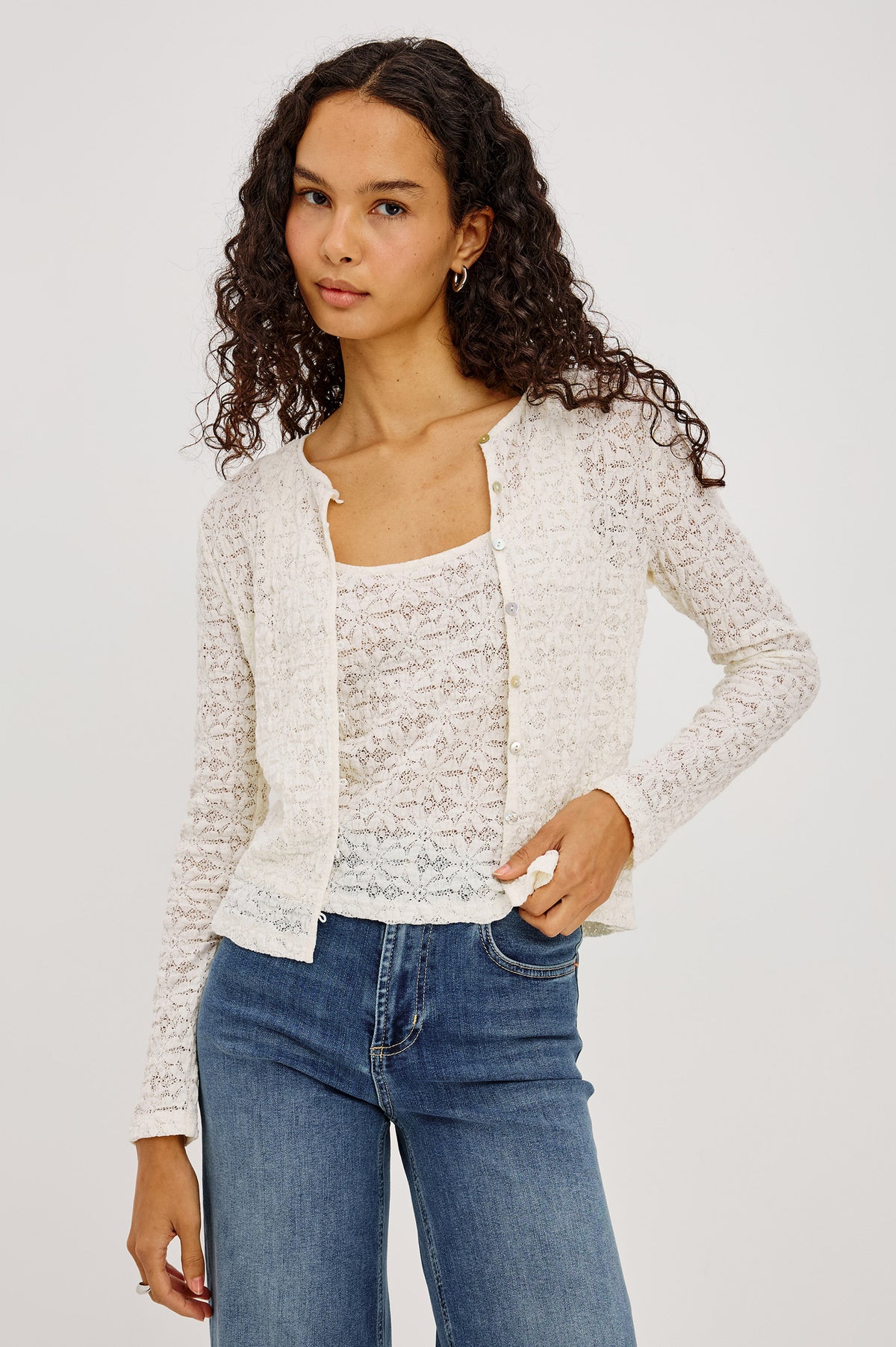 Cyrah Top in Sheer Stretch Lace With Long Sleeves, Front Button-and-Loop Closures, Crew Neckline, and Fitted Silhouette in Ivory Colorway - Upper Body Front View Featured on Model