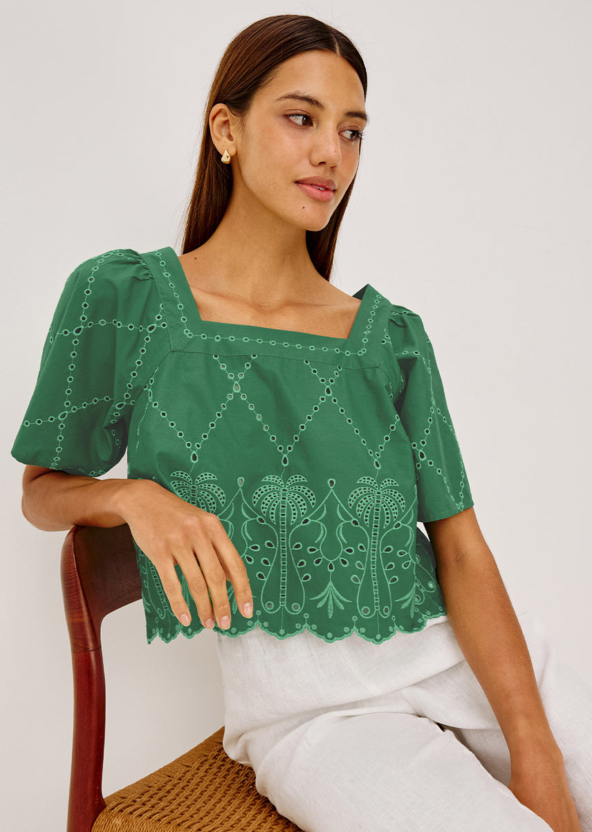 Woman in a green top and white pants