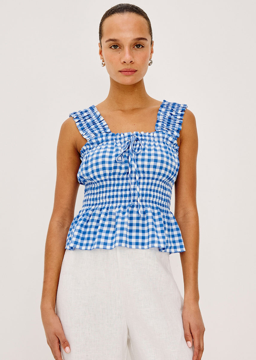 Woman wearing a blue and white checkered top against a plain background