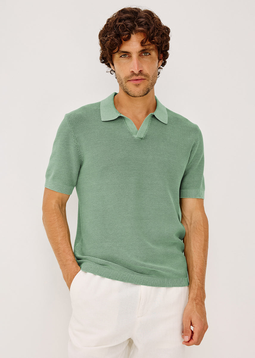 Man in a green shirt and white pants