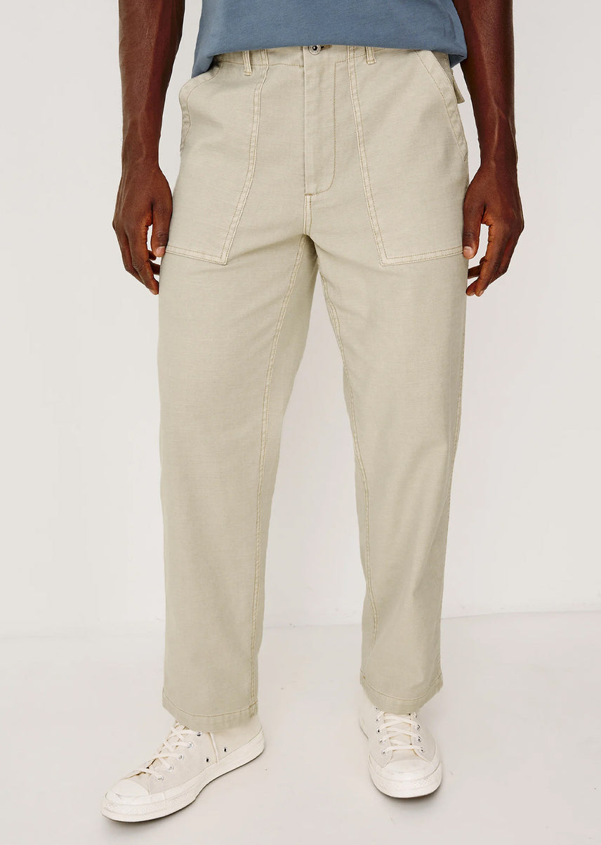 Person wearing beige pants and white sneakers on a white background