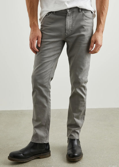 Person wearing gray pants and black shoes on a plain background