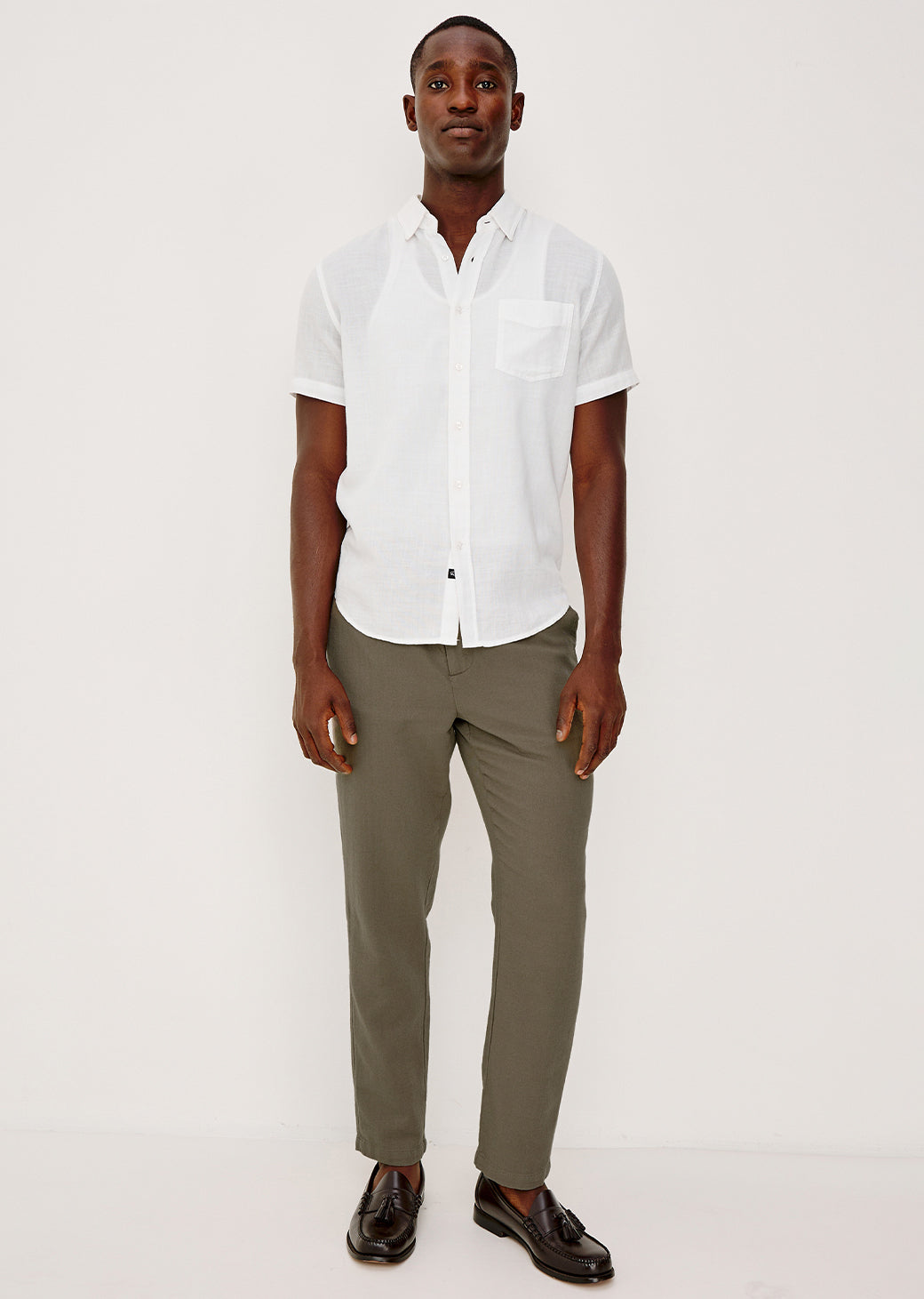 Man wearing a white shirt and green pants on a white background