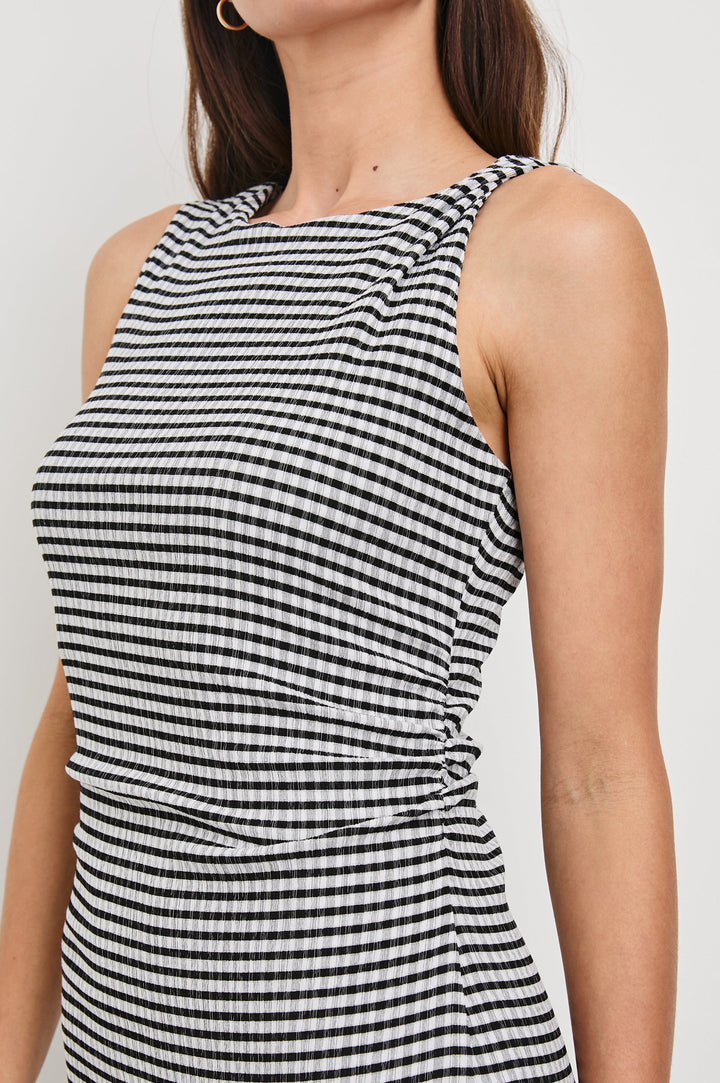 Daija Sleeveless Midi Dress with a Pleated Asymmetrical Hemline, and a Crew Neckline in Black Gingham Colorway - Front View Featured on Model