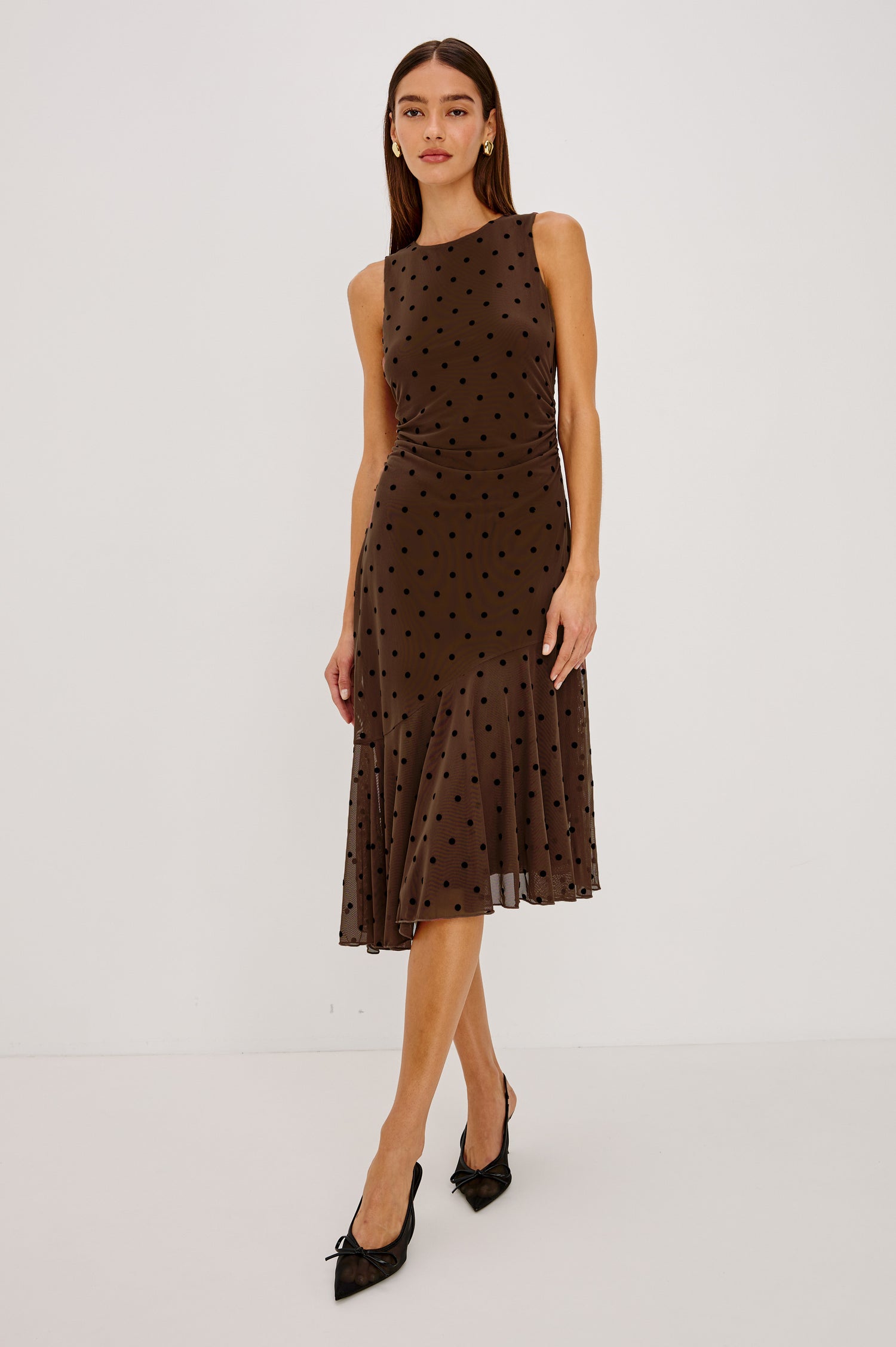 Daija Midi Dress in Self-Lined Mesh With High Neckline, Fitted Bodice, Side Waist Ruching, Bias Cut Skirt, and Asymmetric Hem in Chocolate Polka Dot Colorway - Full Body Front View Featured on Model