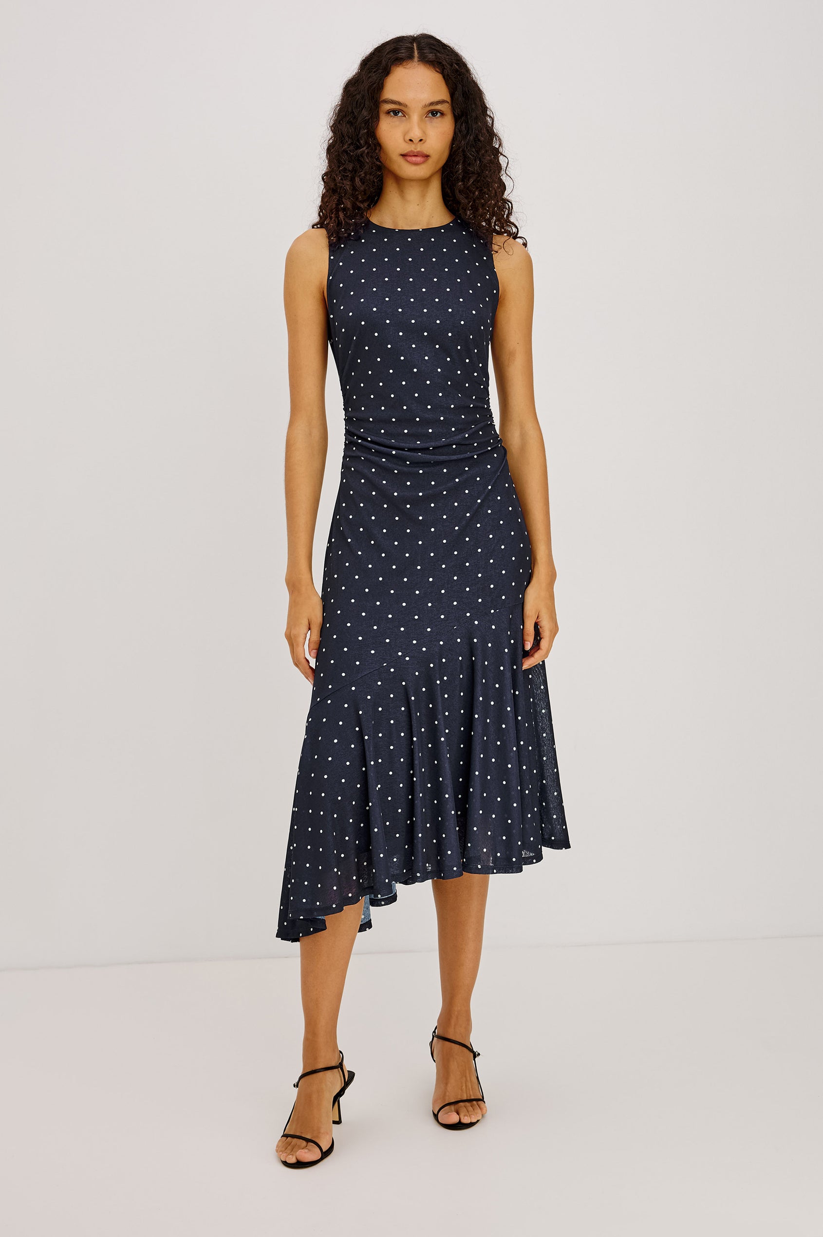 Daija Midi Dress in Self-Lined Mesh With High Neckline, Fitted Bodice, Side Waist Ruching, Bias Cut Skirt, and Asymmetric Hem in Chocolate Polka Dot Colorway - Full Body Front View Featured on Model