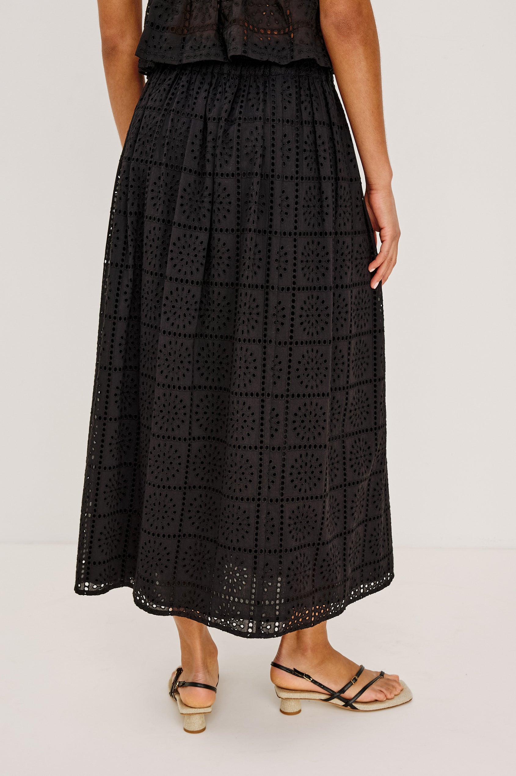 Dax A-Line Maxi Skirt With Grid and Floral Cutwork Embroidery, Elastic Waistband, and is Fully Lined in Black Grid Embroidery Embroidery Colorway - Lower Body Back View Featured on Model