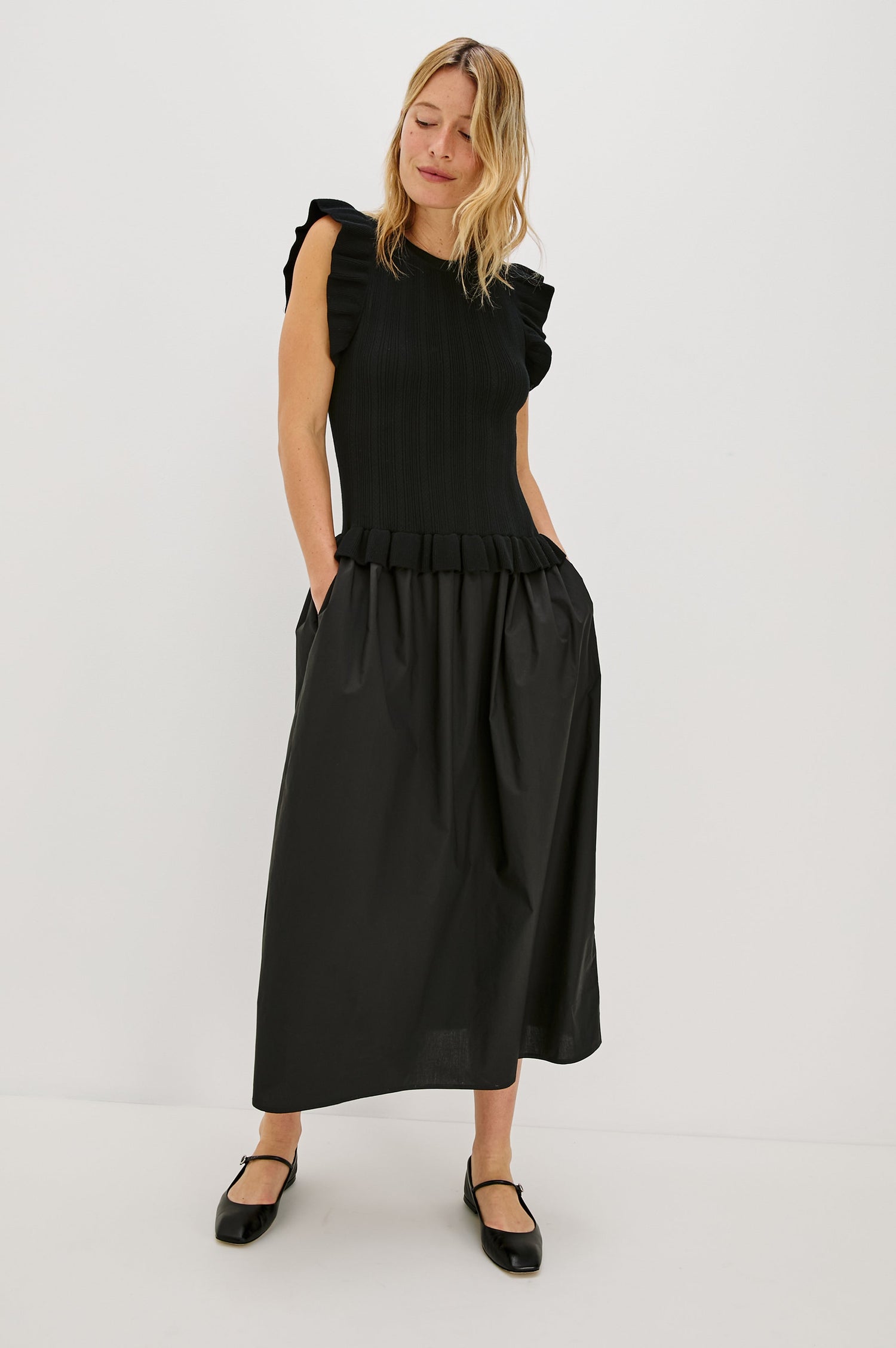 Deirdre, a maxi dress with a fitted fine-gauge knit bodice and flutter sleeves. The dress transitions at the waist into a full cotton poplin skirt, creating a soft, mixed-fabric silhouette. Full Body Front View featured on Model.